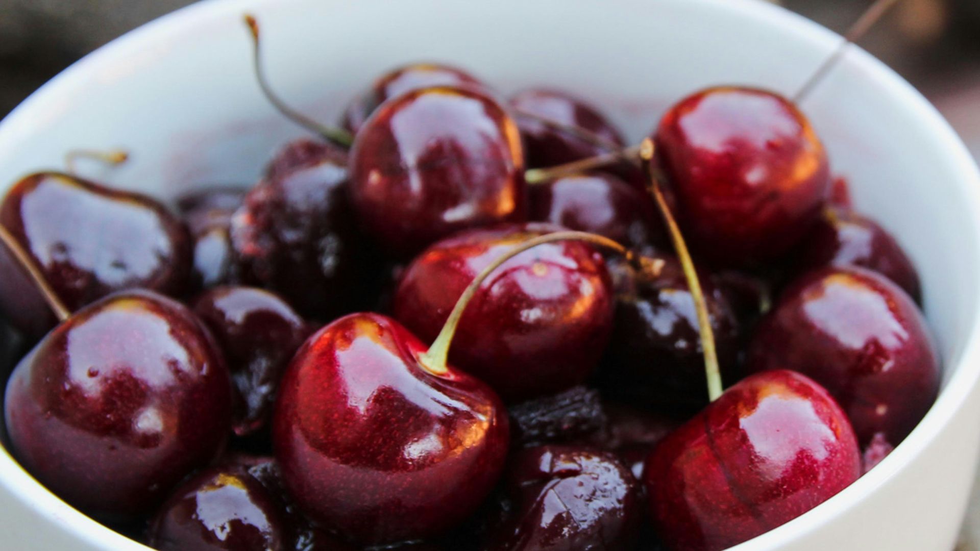red cherries in white ceramic bowl