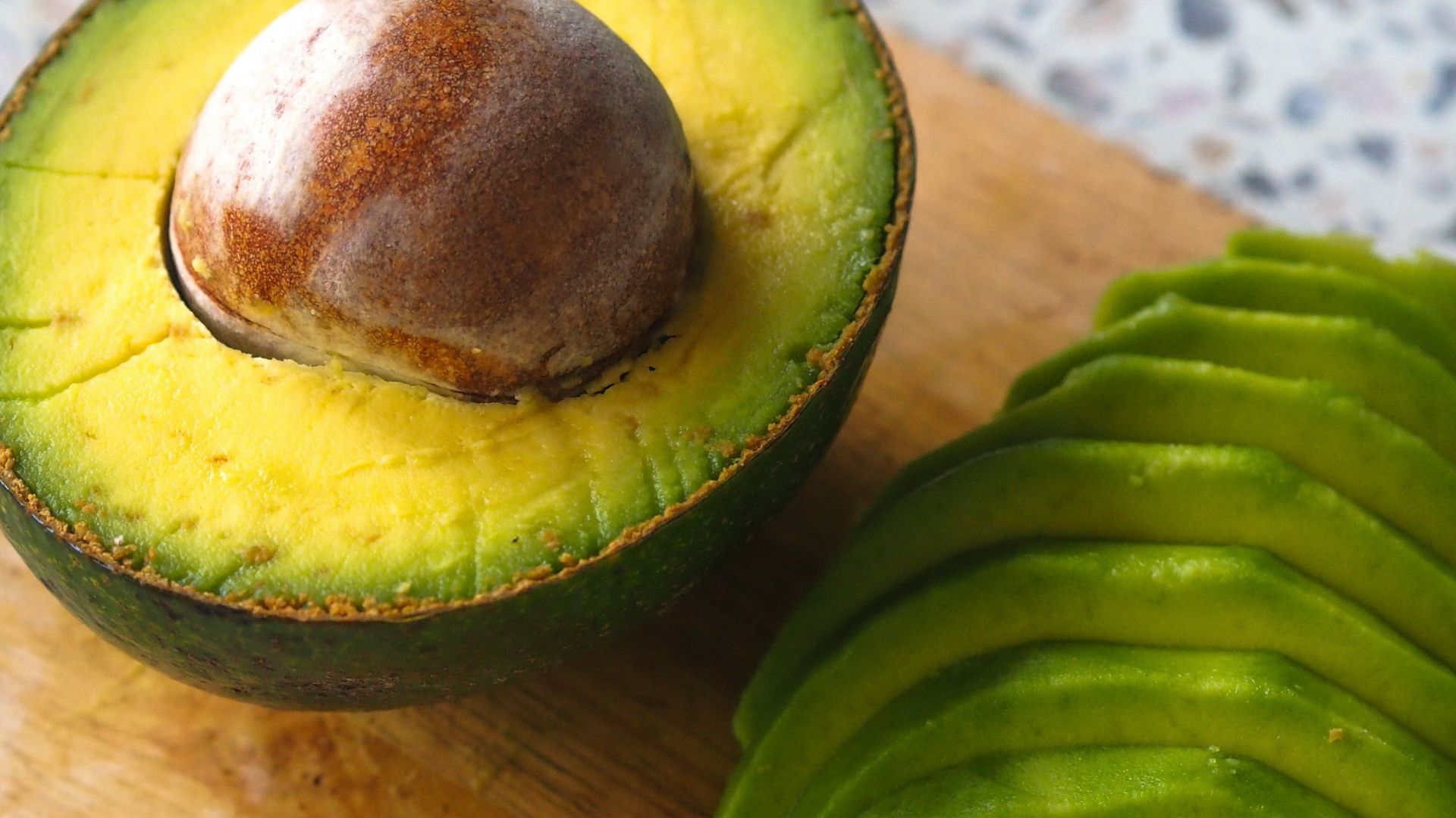 an avocado cut in half on a cutting board