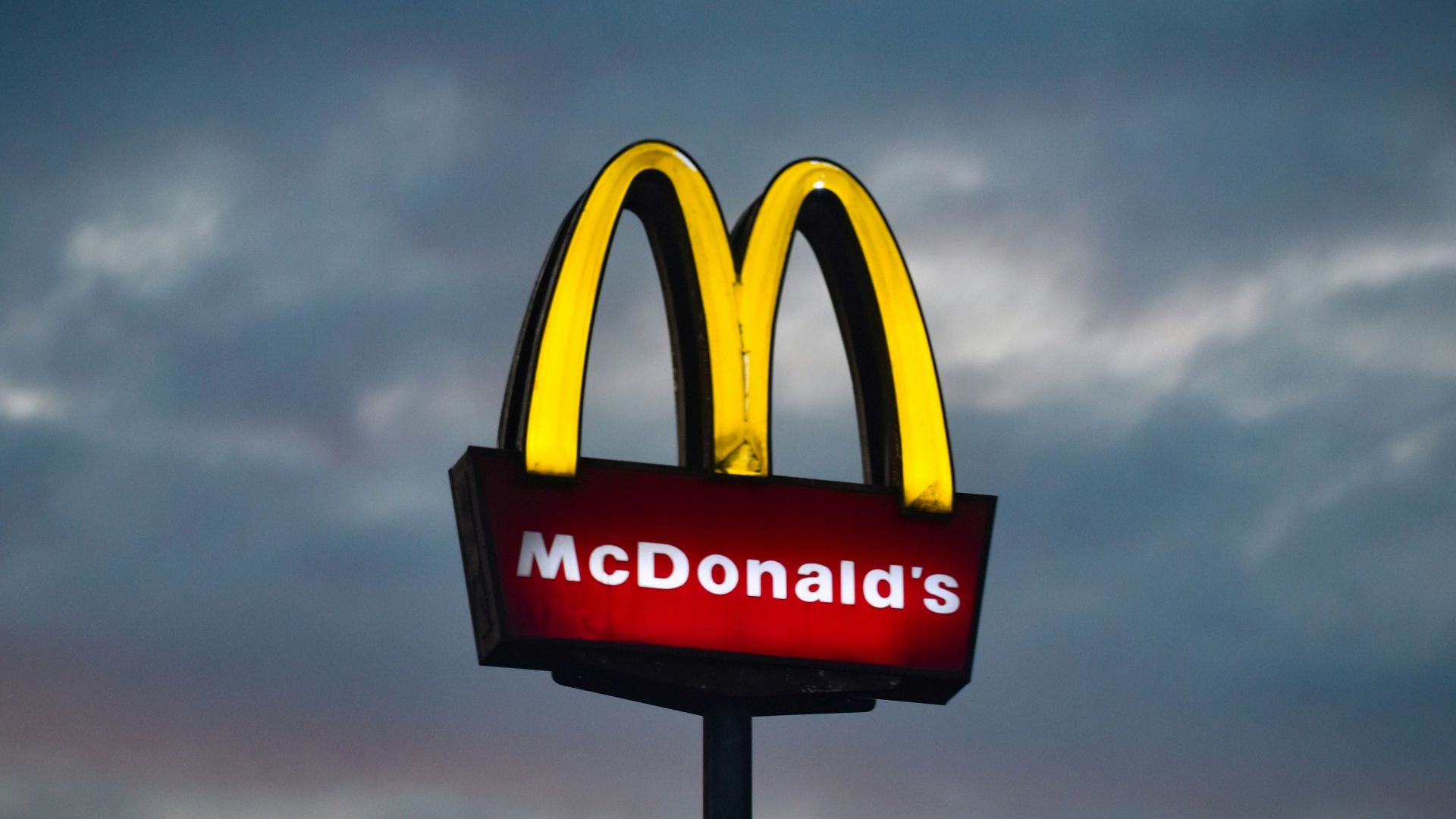 a mcdonald's sign with a cloudy sky in the background