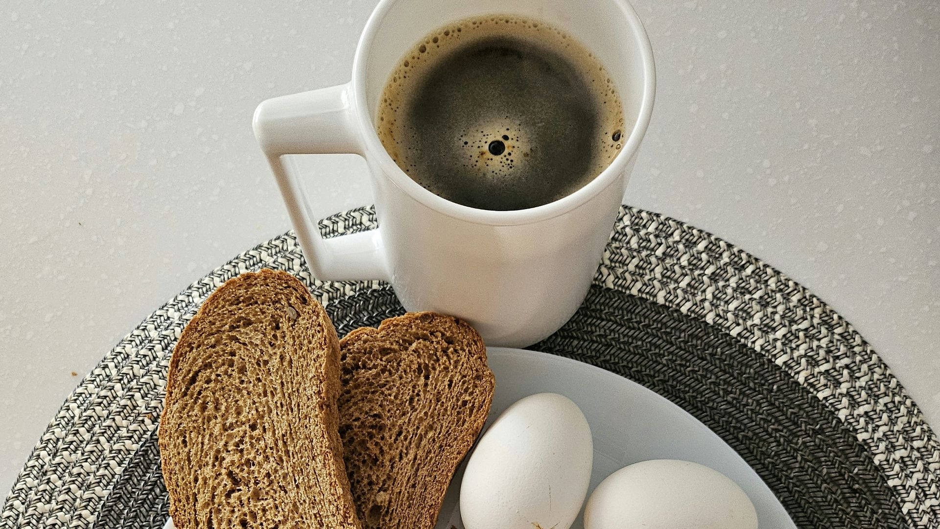 A white plate topped with sliced apples and a cup of coffee