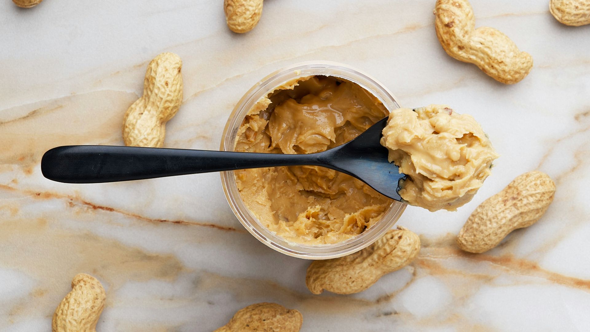 peanut butter with black spoon