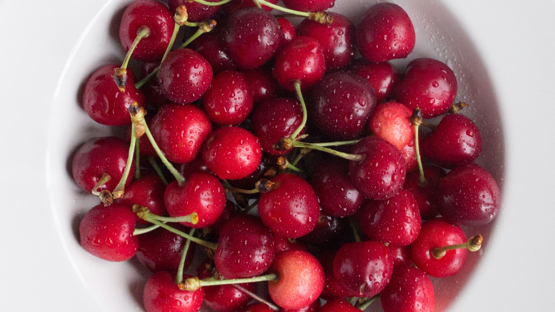red cherries on white ceramic plate