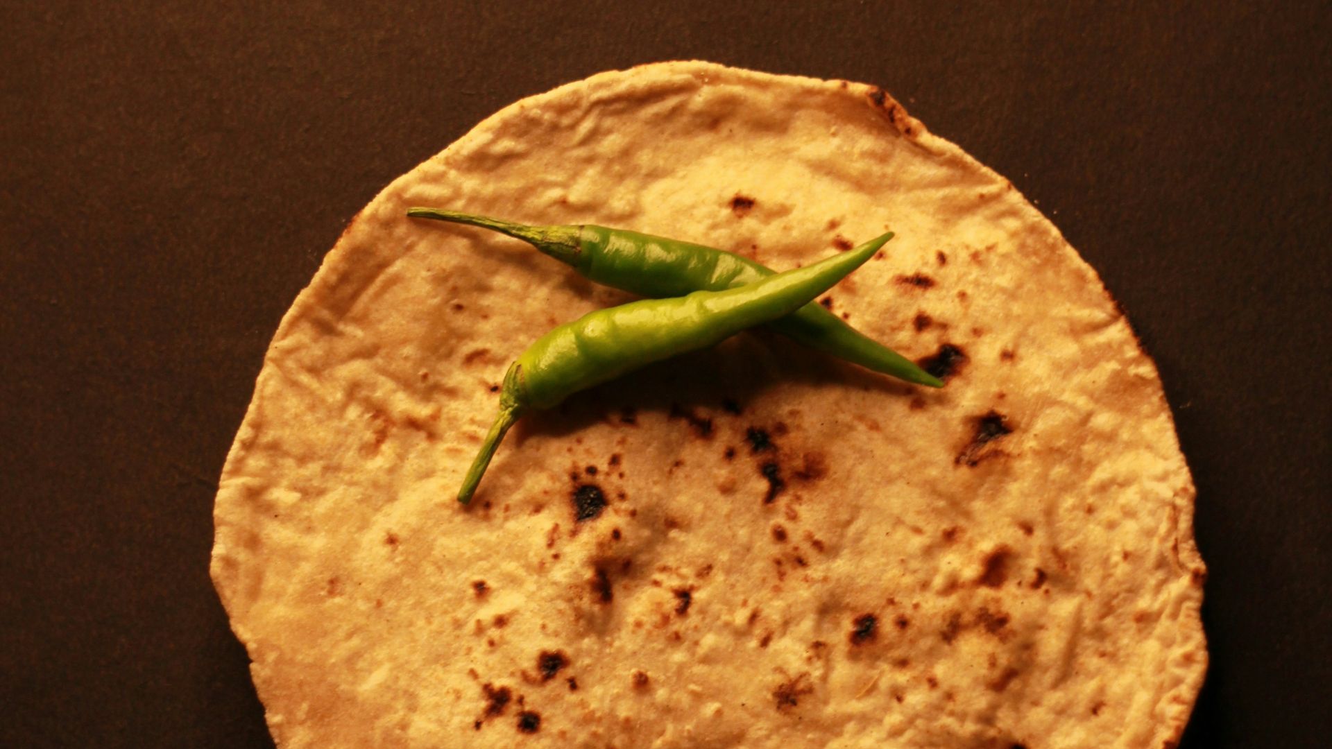 A tortilla with a green pepper on top of it