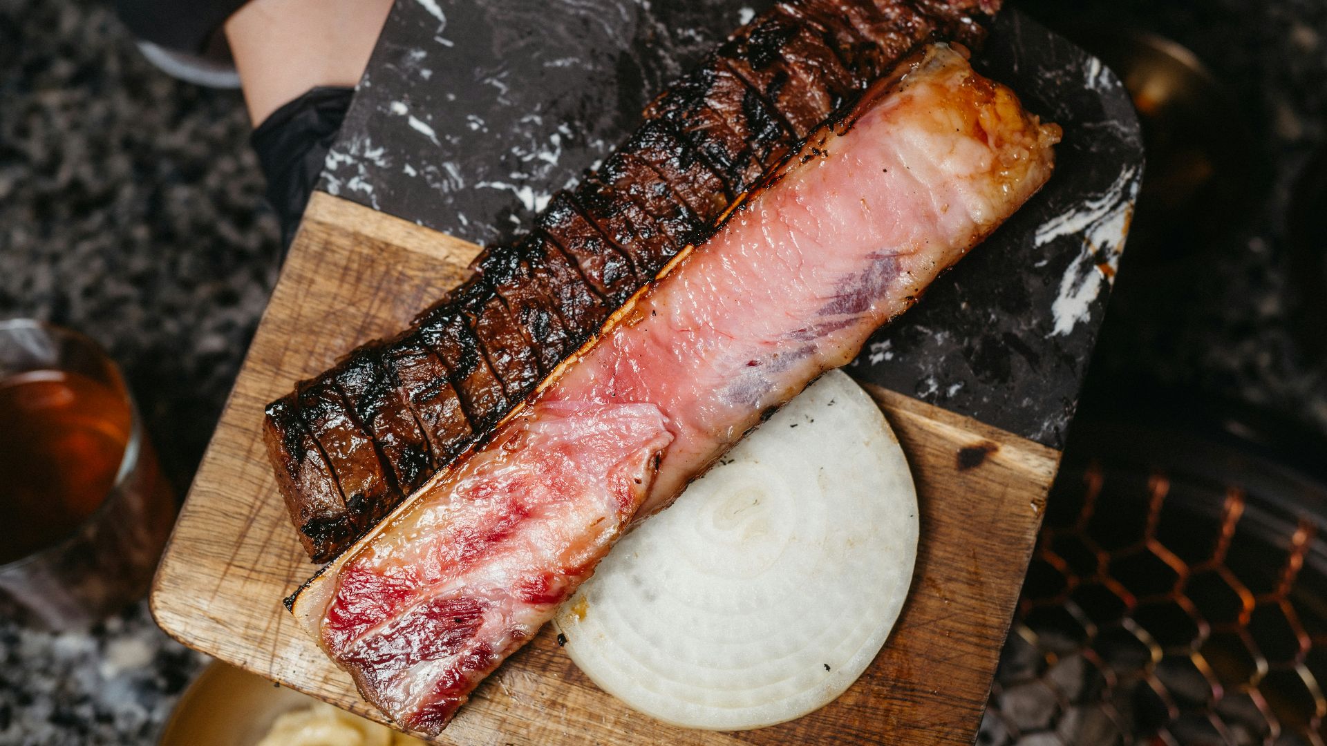 a person holding a piece of meat on a cutting board