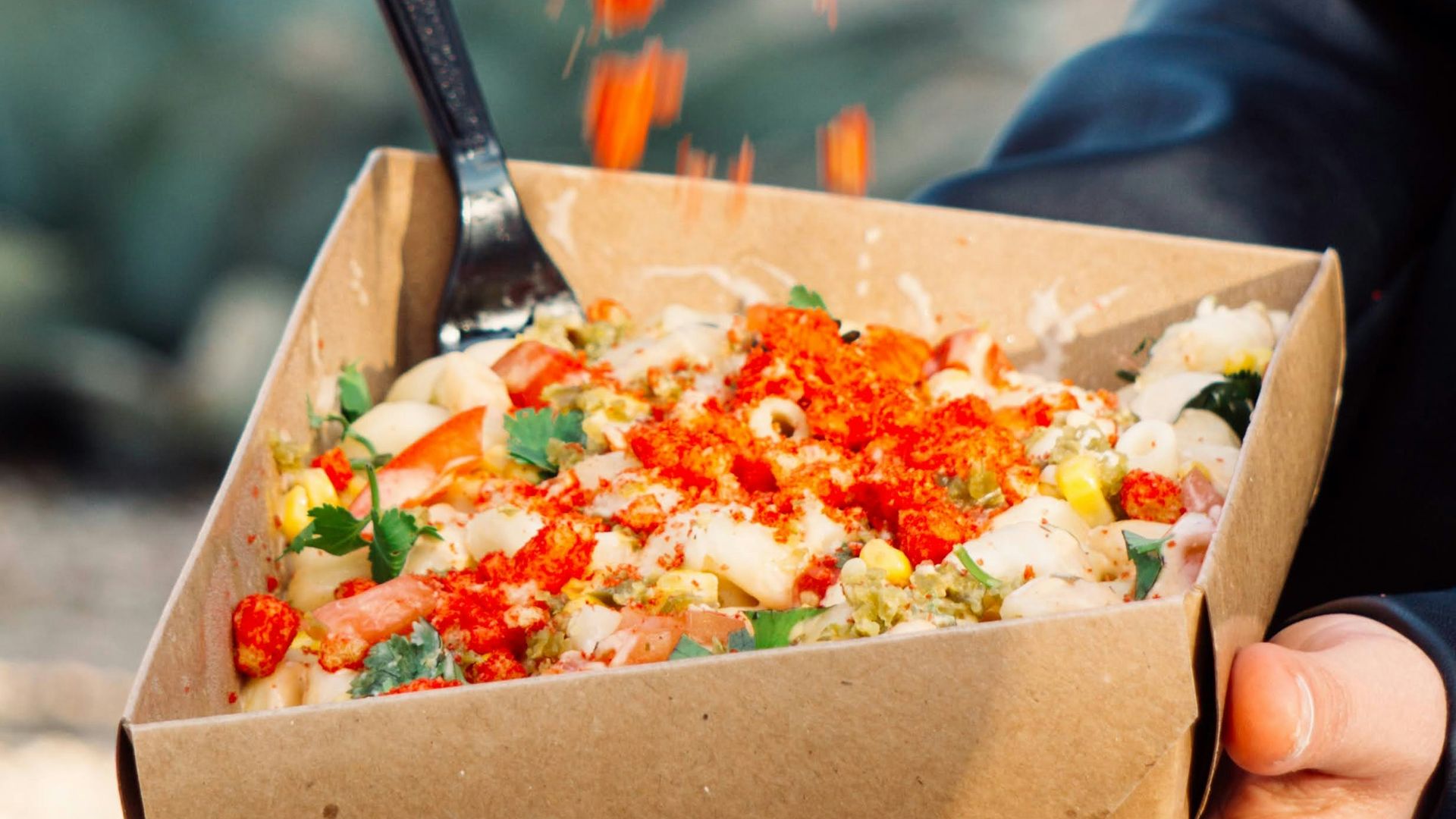 person holding brown box with vegetable salad