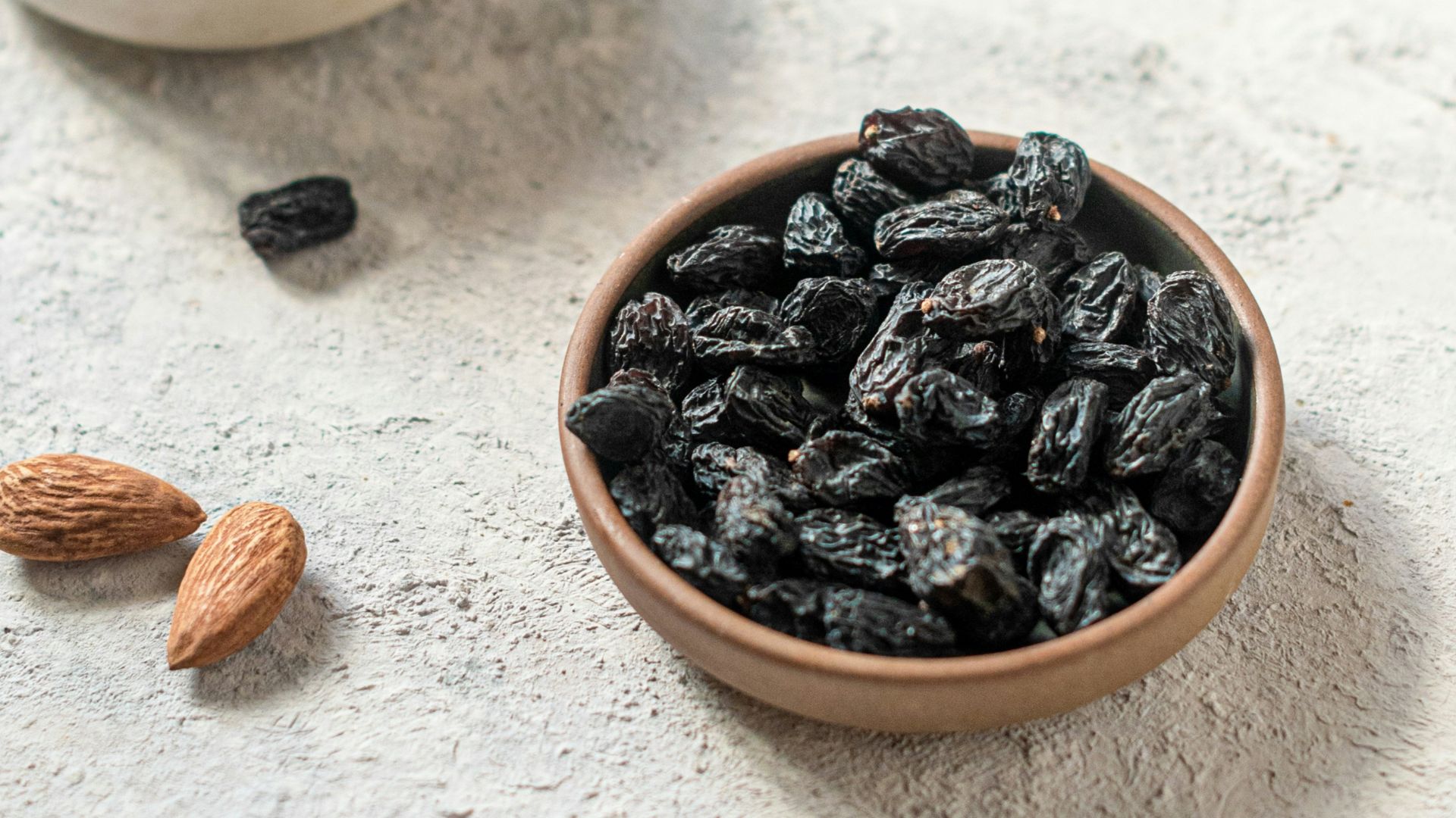 brown and black coffee beans on white ceramic bowl