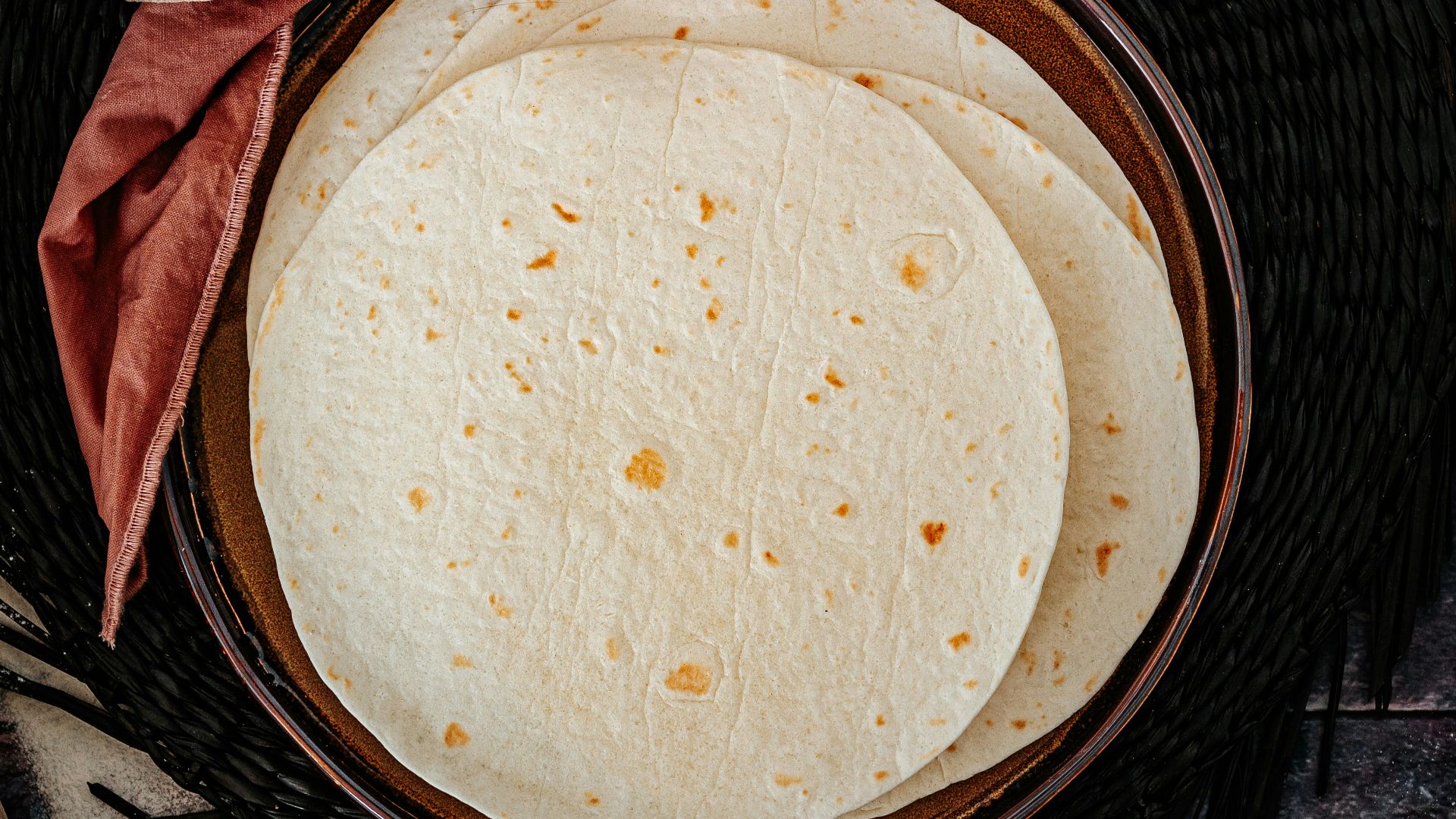 brown woven round basket on black and gray textile
