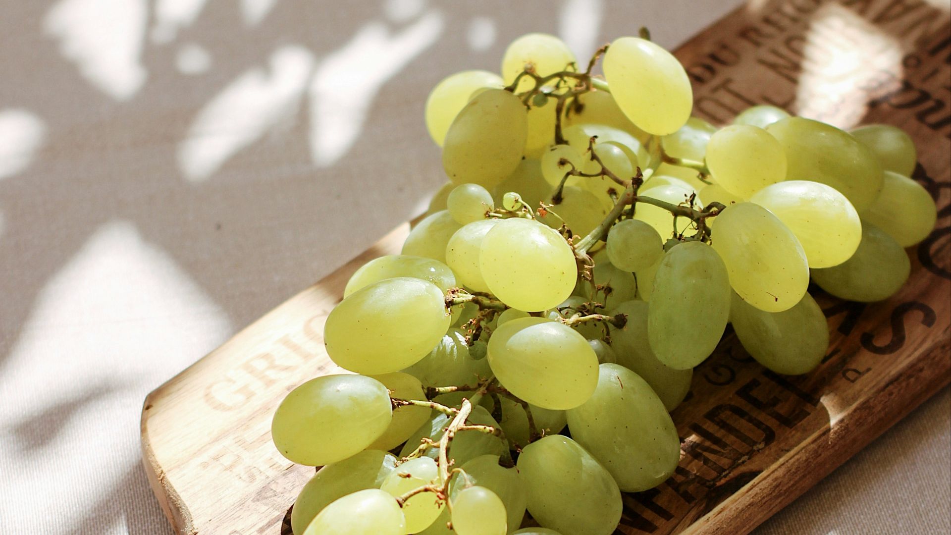 green grapes on brown wooden chopping board
