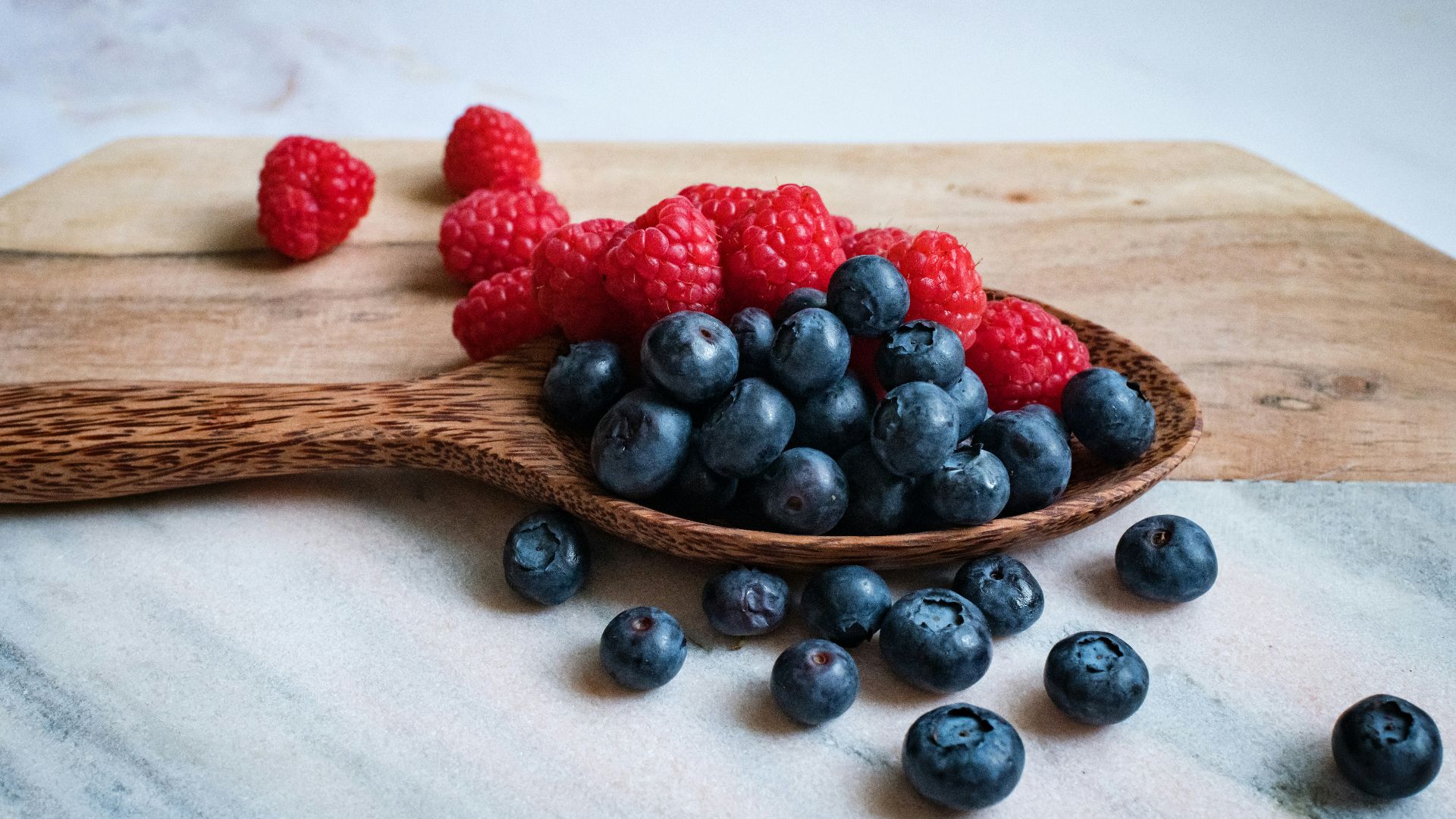 black berries on brown wooden spoon