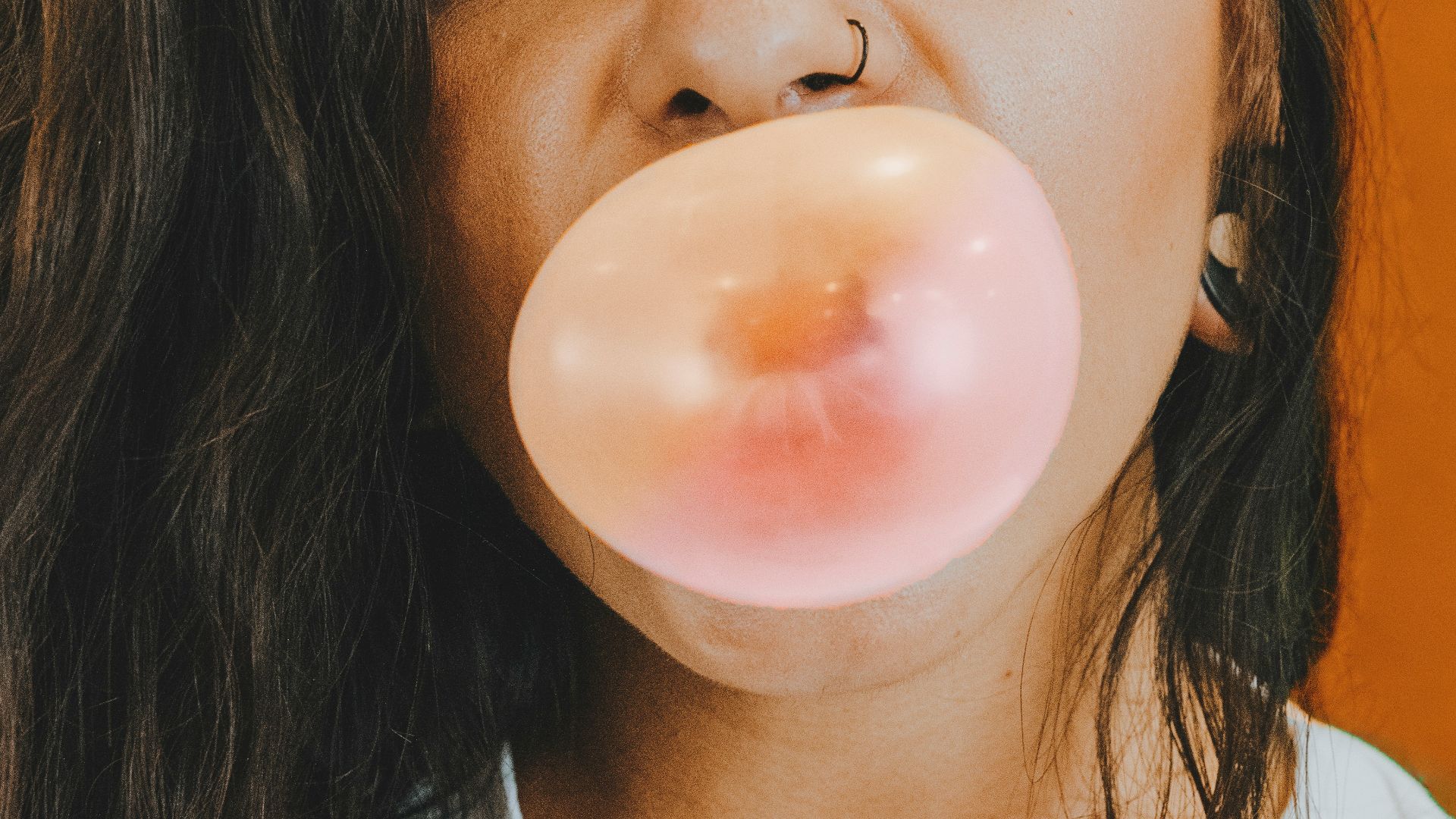 woman in white crew neck shirt blowing bubble
