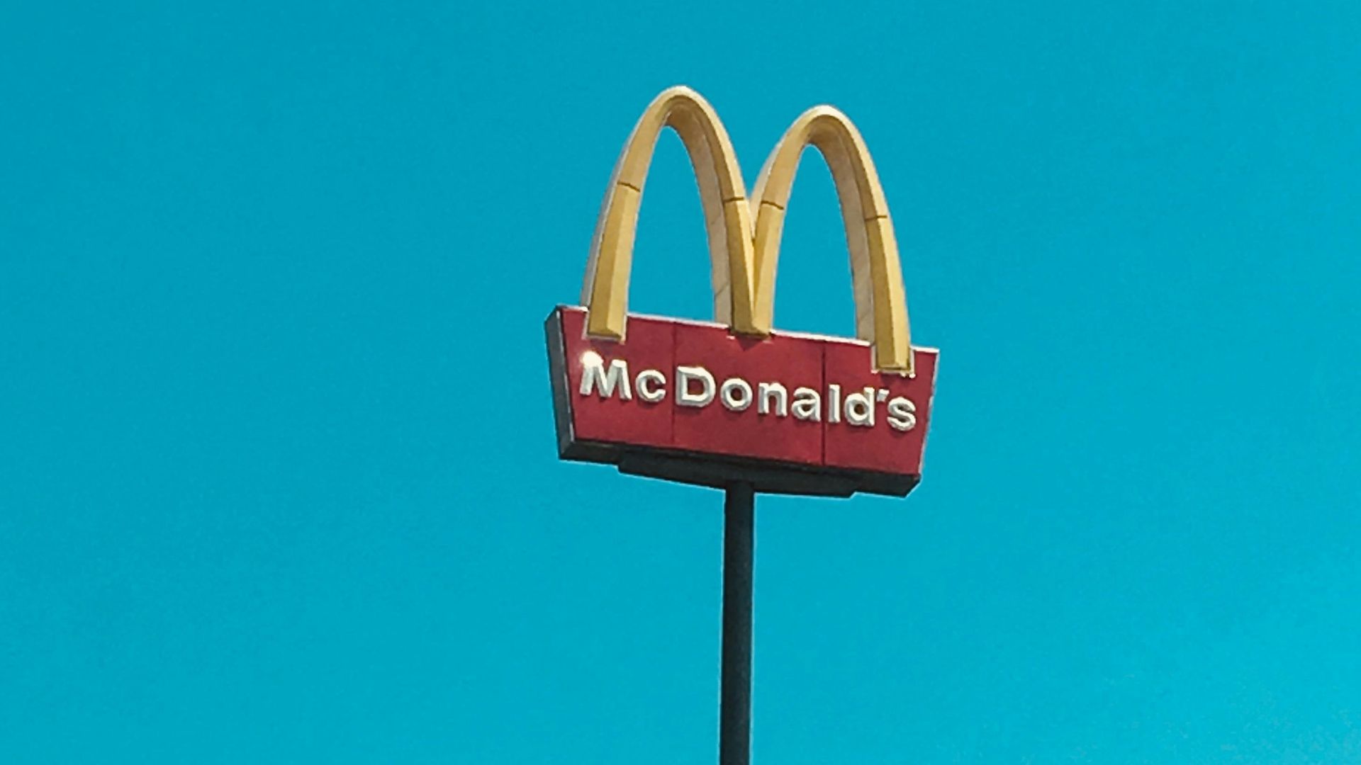 a mcdonald's restaurant sign in front of a blue sky