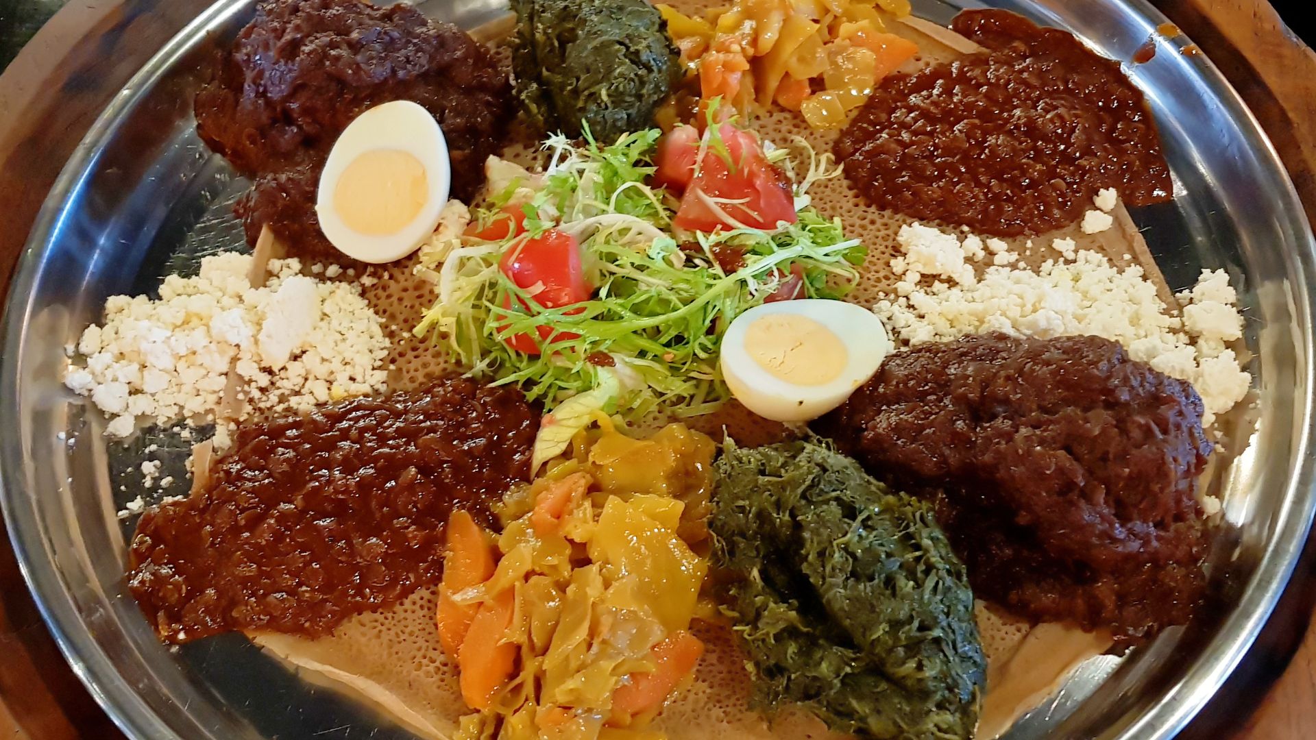 File:A formal serving of wat atop injera in Brussels, Belgium.jpg