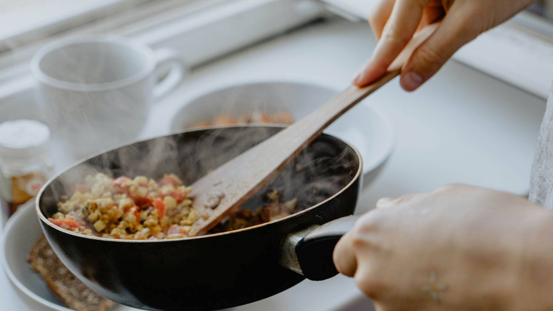 person holding black frying pan