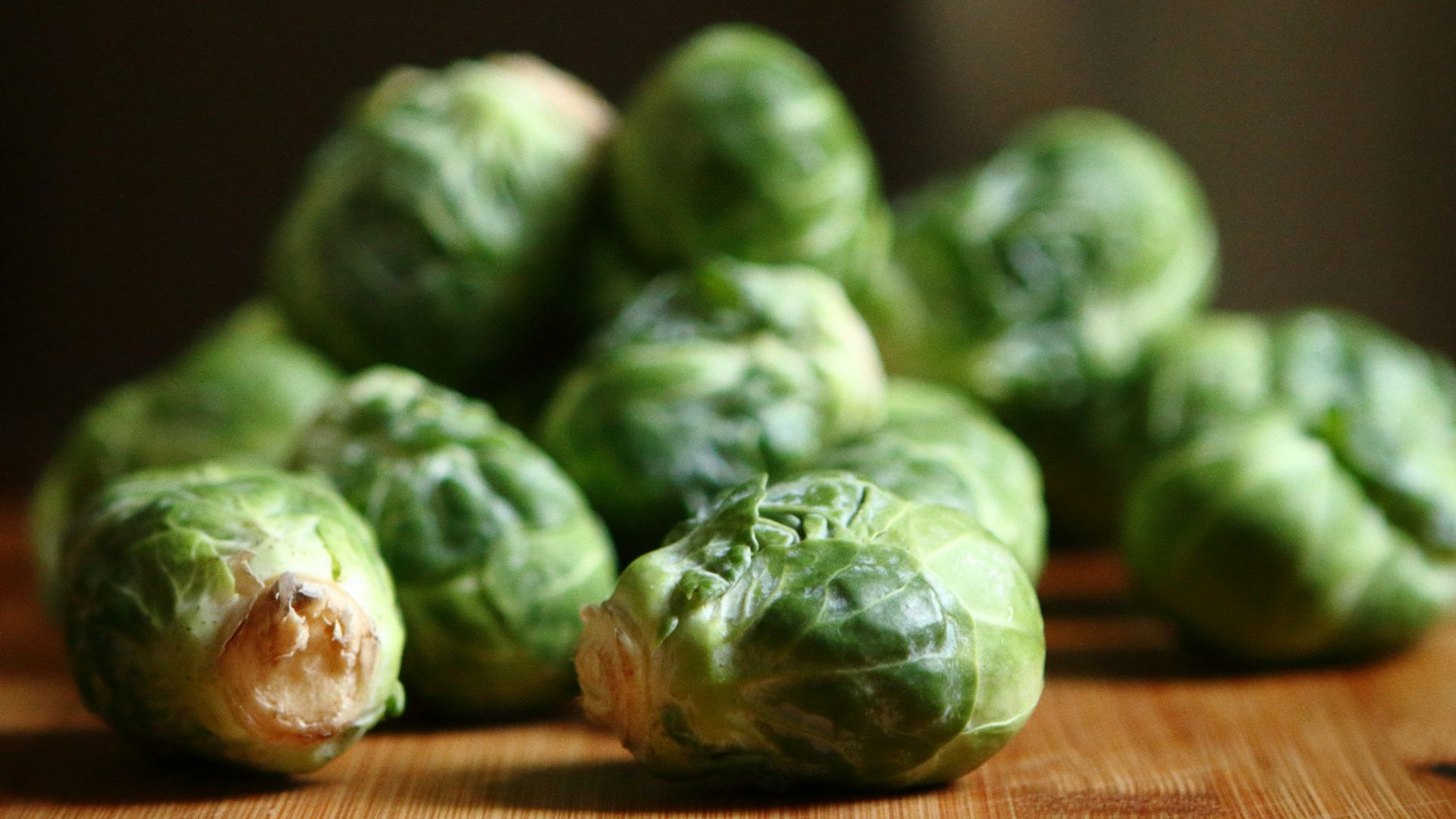 shallow depth of fields photography of green vegetable on brown wooden panel