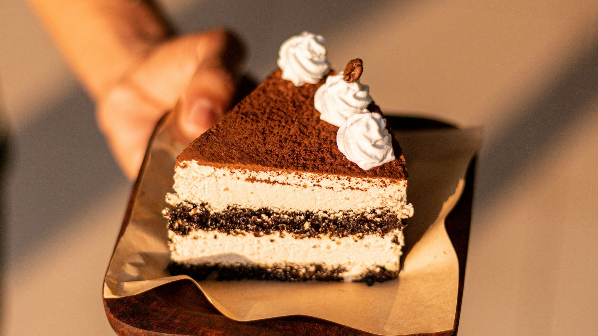 a person holding a piece of cake on a plate