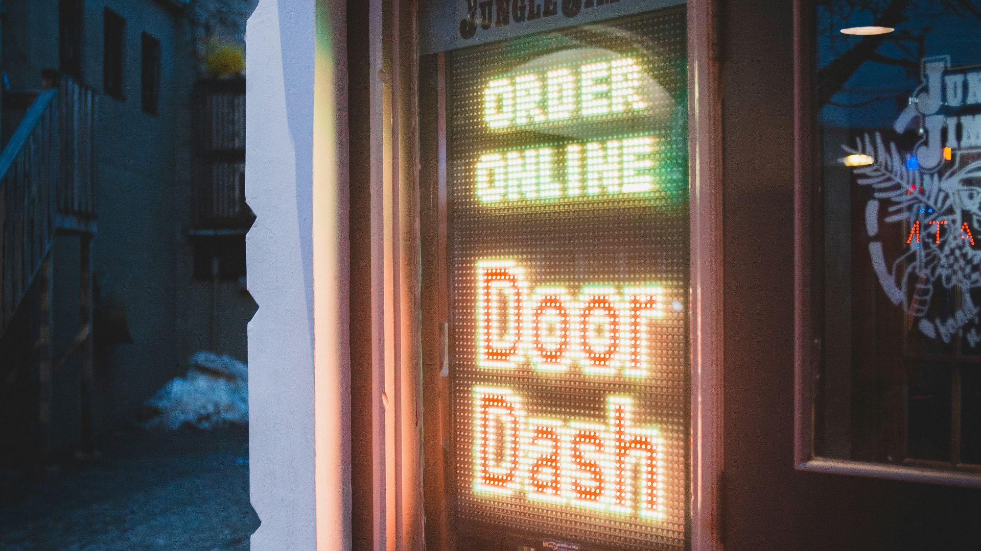 brown wooden door with red and yellow neon sign