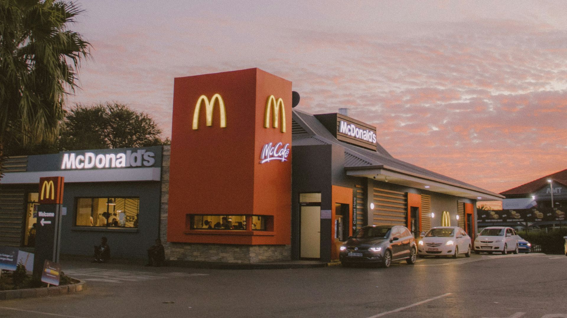 red and white concrete building near palm trees during daytime