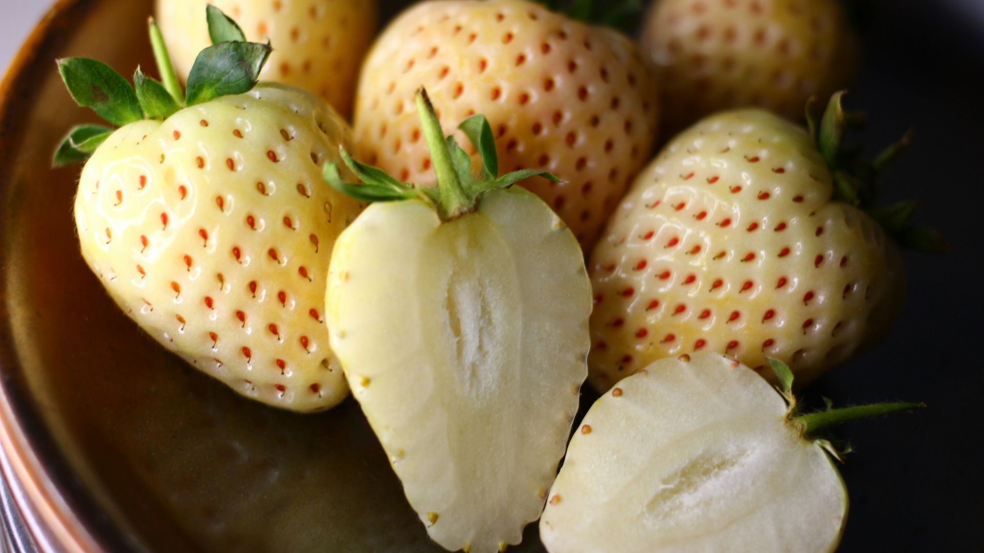 a close up of a plate of strawberries on a table