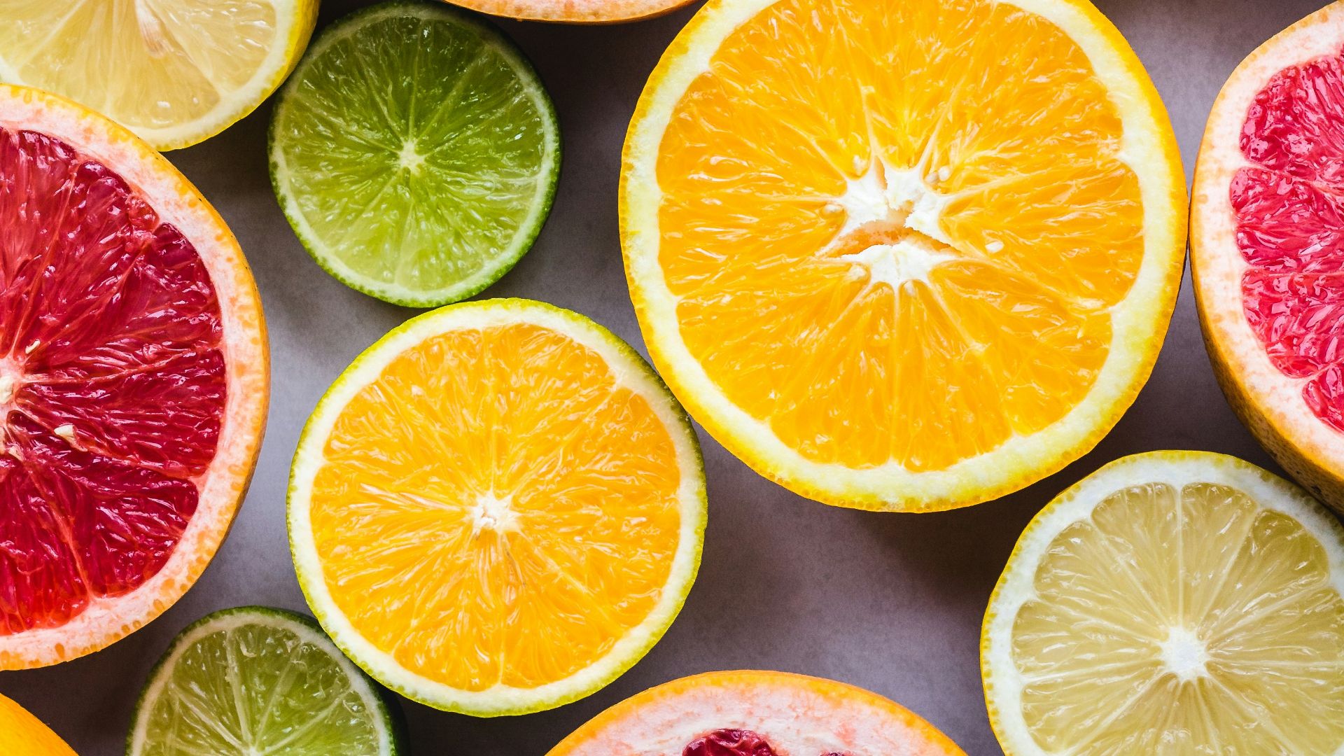 flat lay photography of sliced pomegranate, lime, and lemon