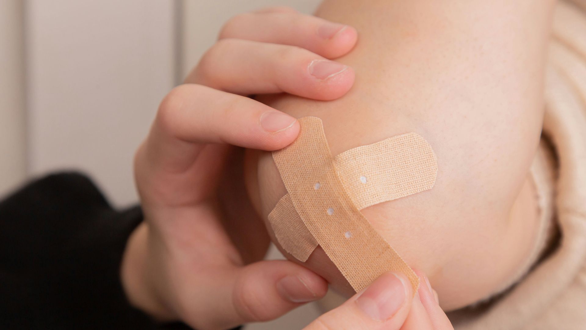 person holding band aid on left hand