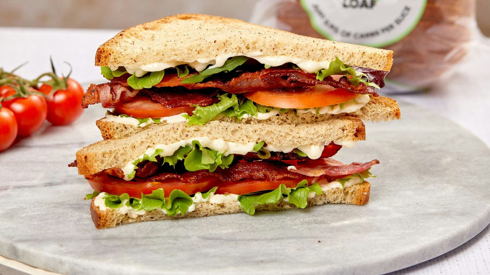 burger with tomato and lettuce on white ceramic plate