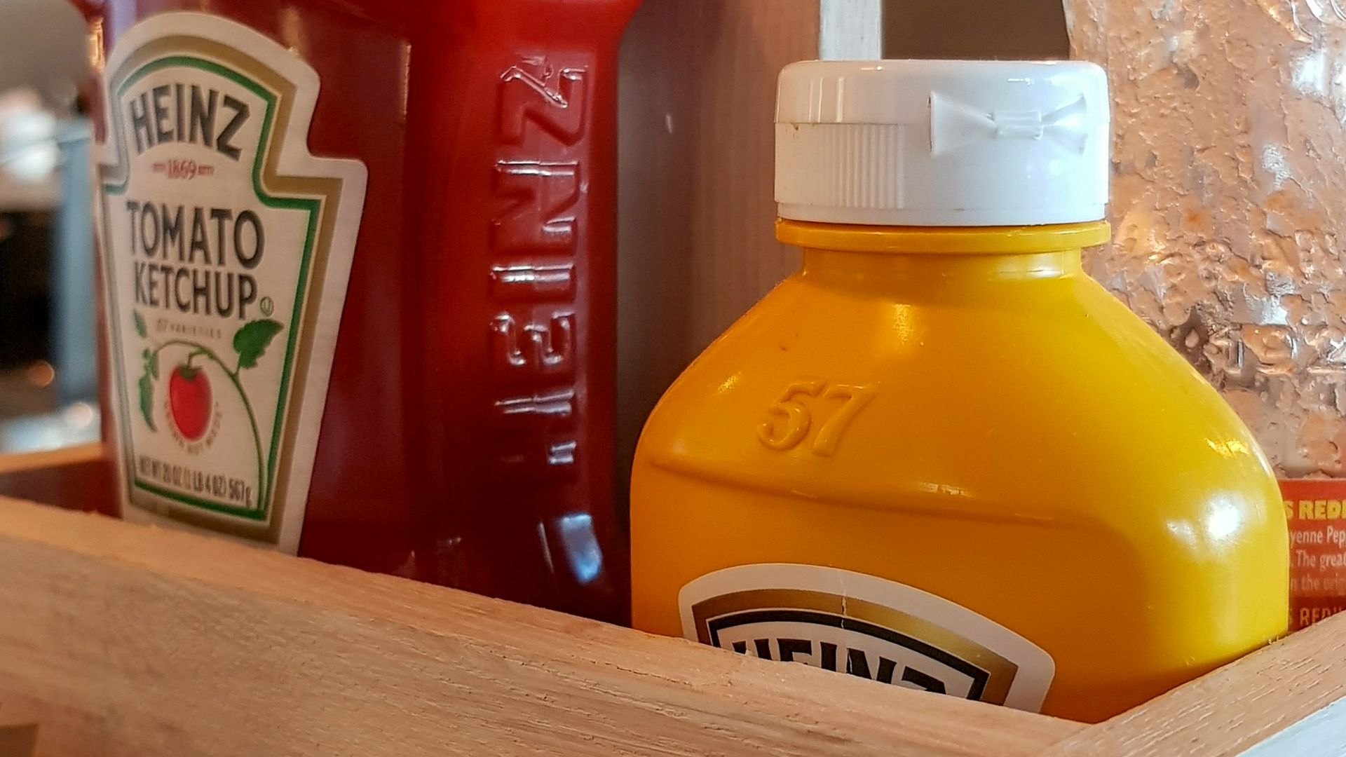 A wooden box filled with juice and condiments