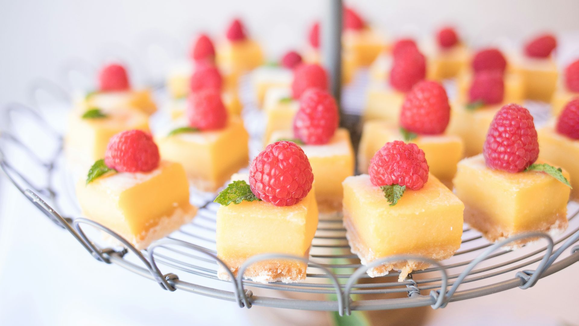 square strawberry cheesecake on round gray metal stand