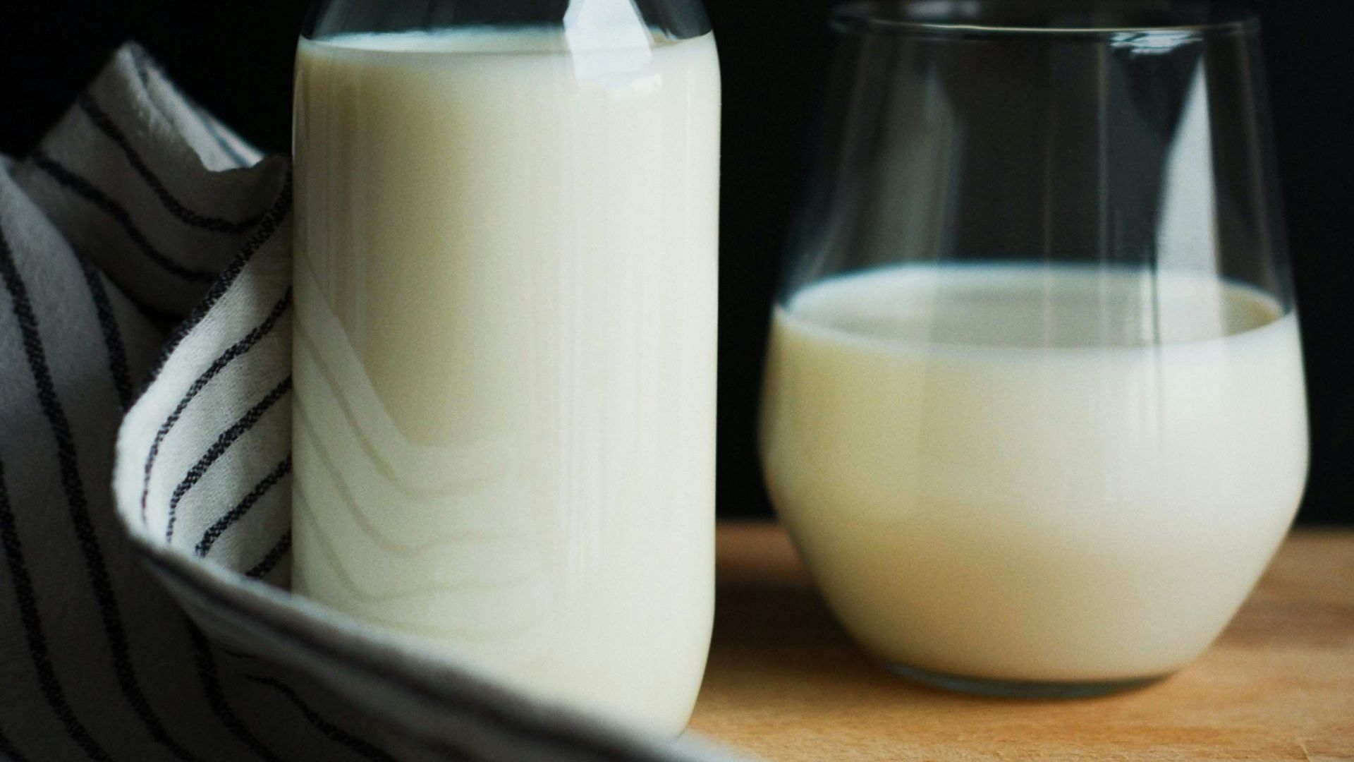 a bottle of milk next to a glass of milk