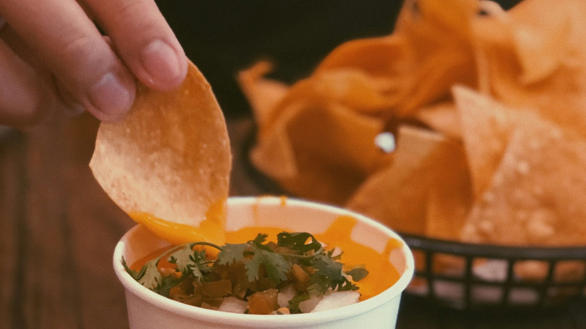 person holding chip pointing on sauce