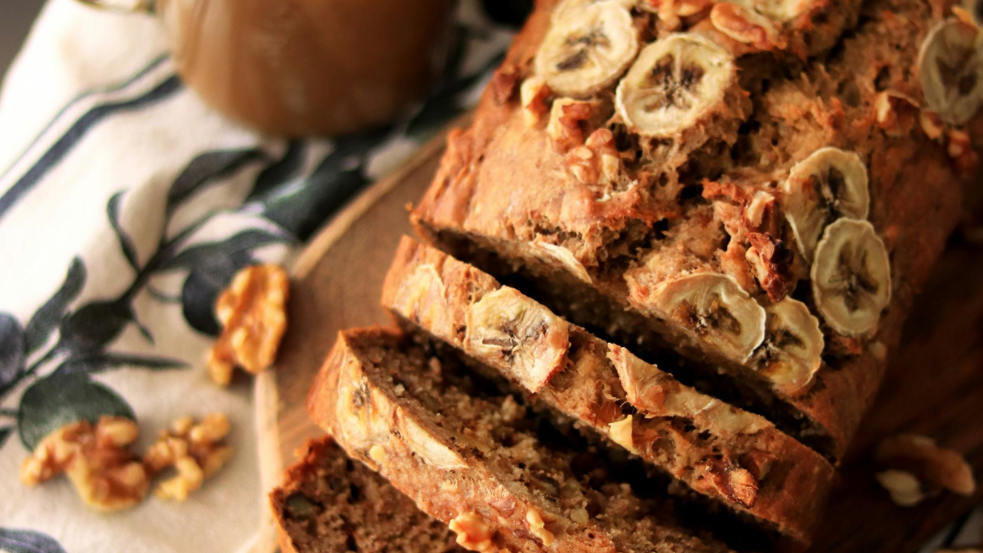 a loaf of banana nut bread sitting on top of a wooden cutting board