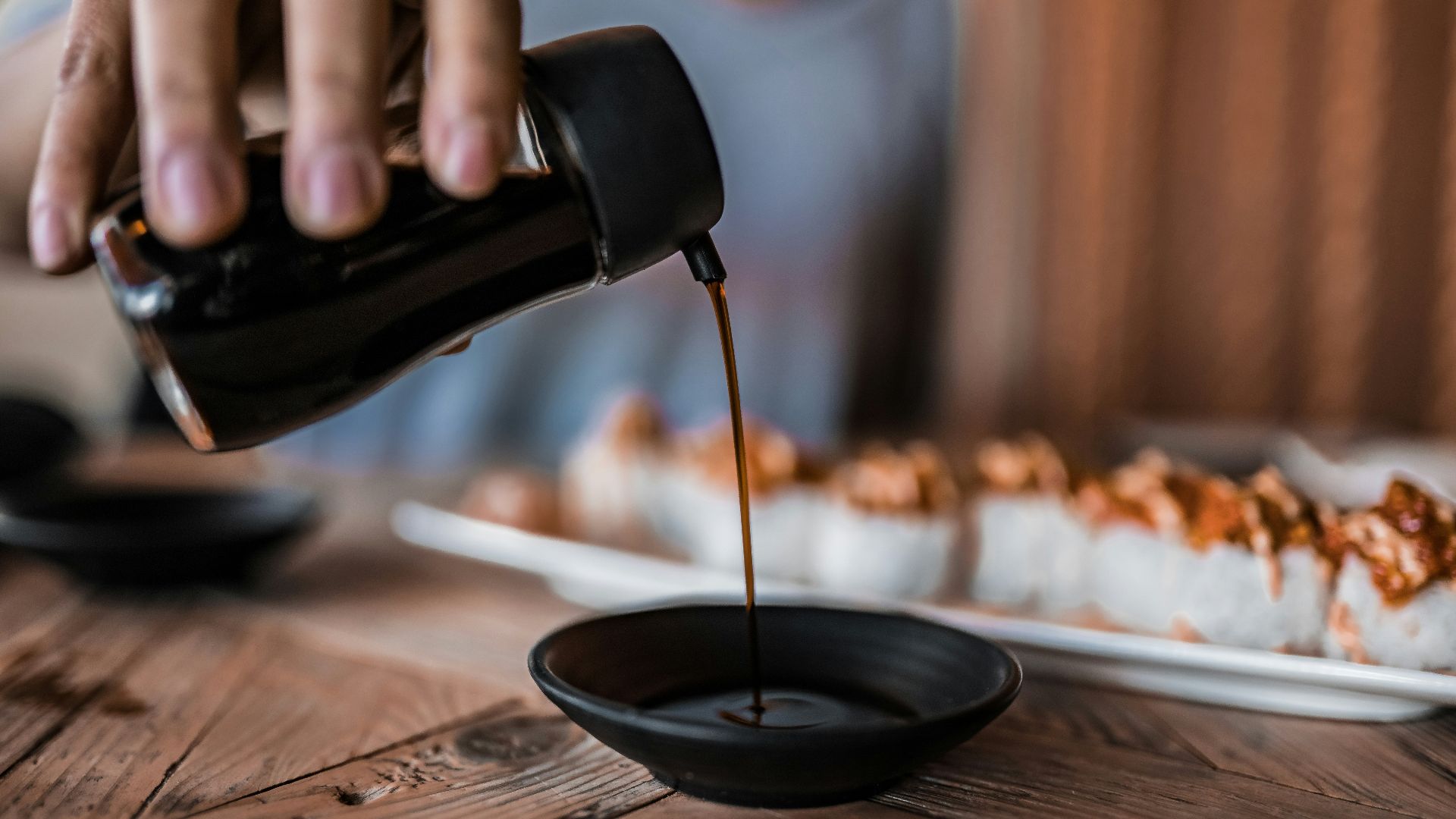 person pouring coffee on black ceramic mug