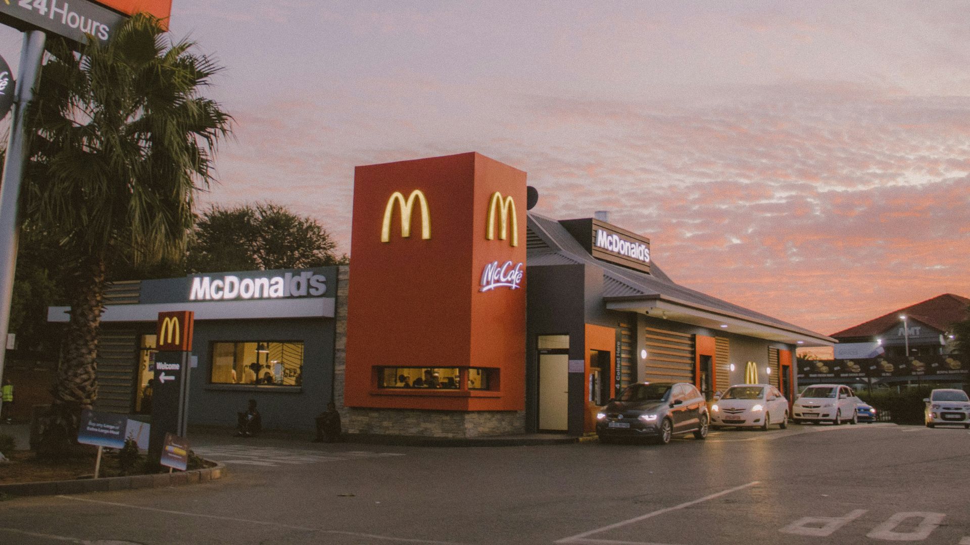 red and white concrete building near palm trees during daytime