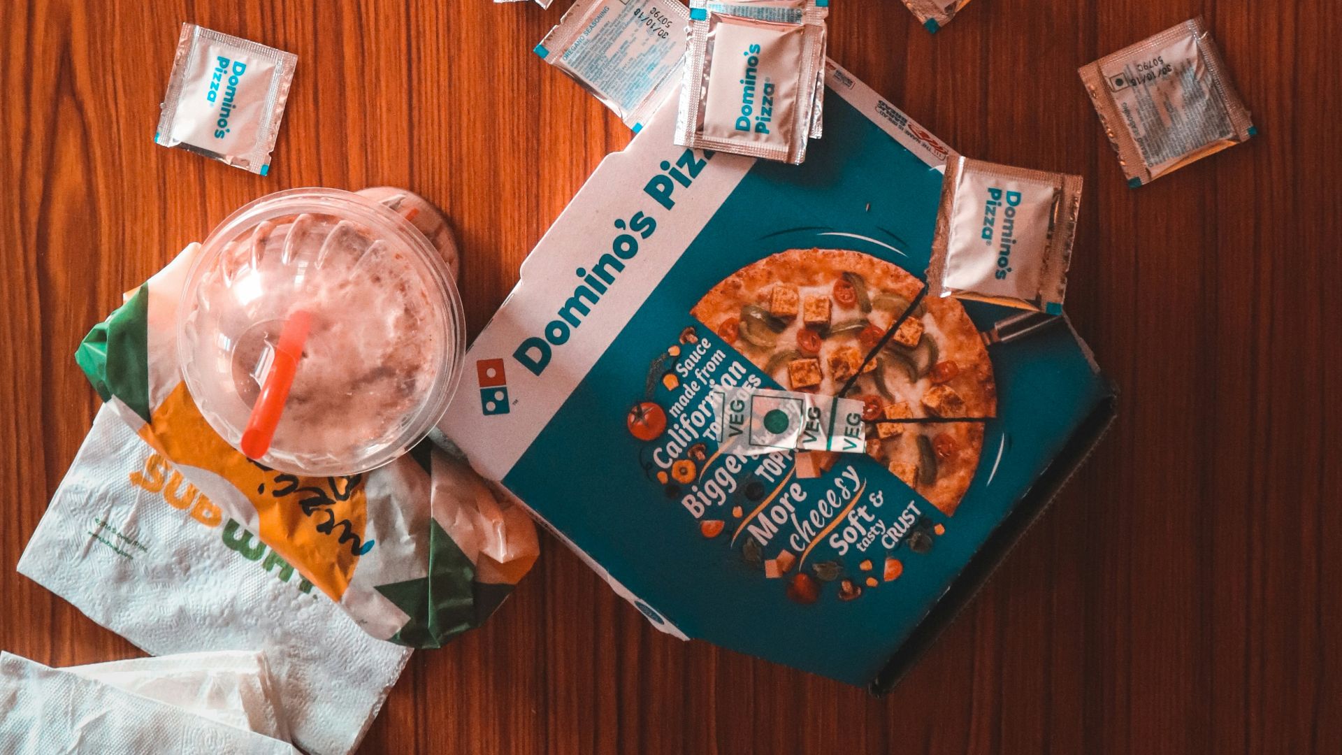 pizza and sauce packs beside iPhone on table