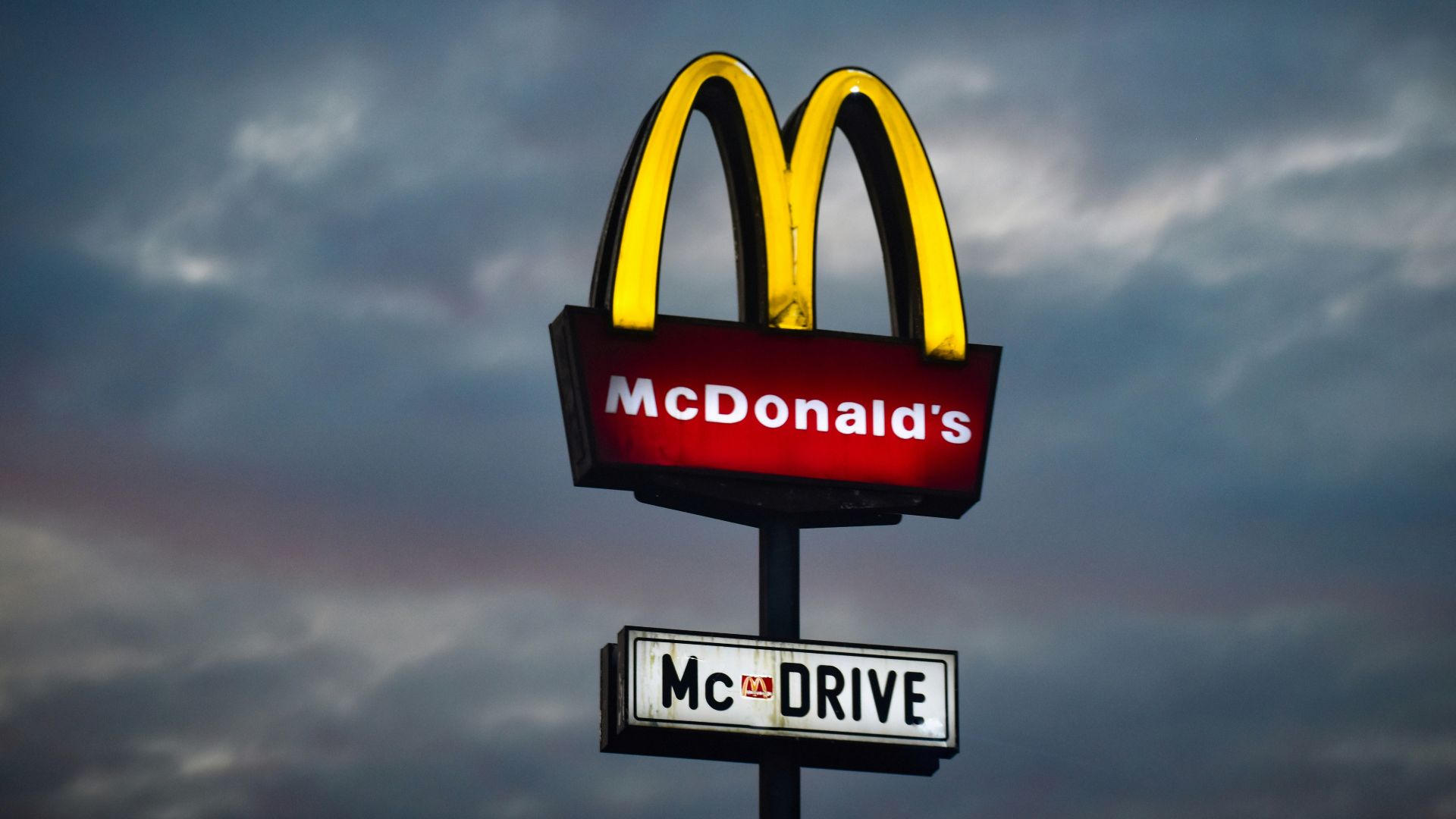 a mcdonald's sign with a cloudy sky in the background