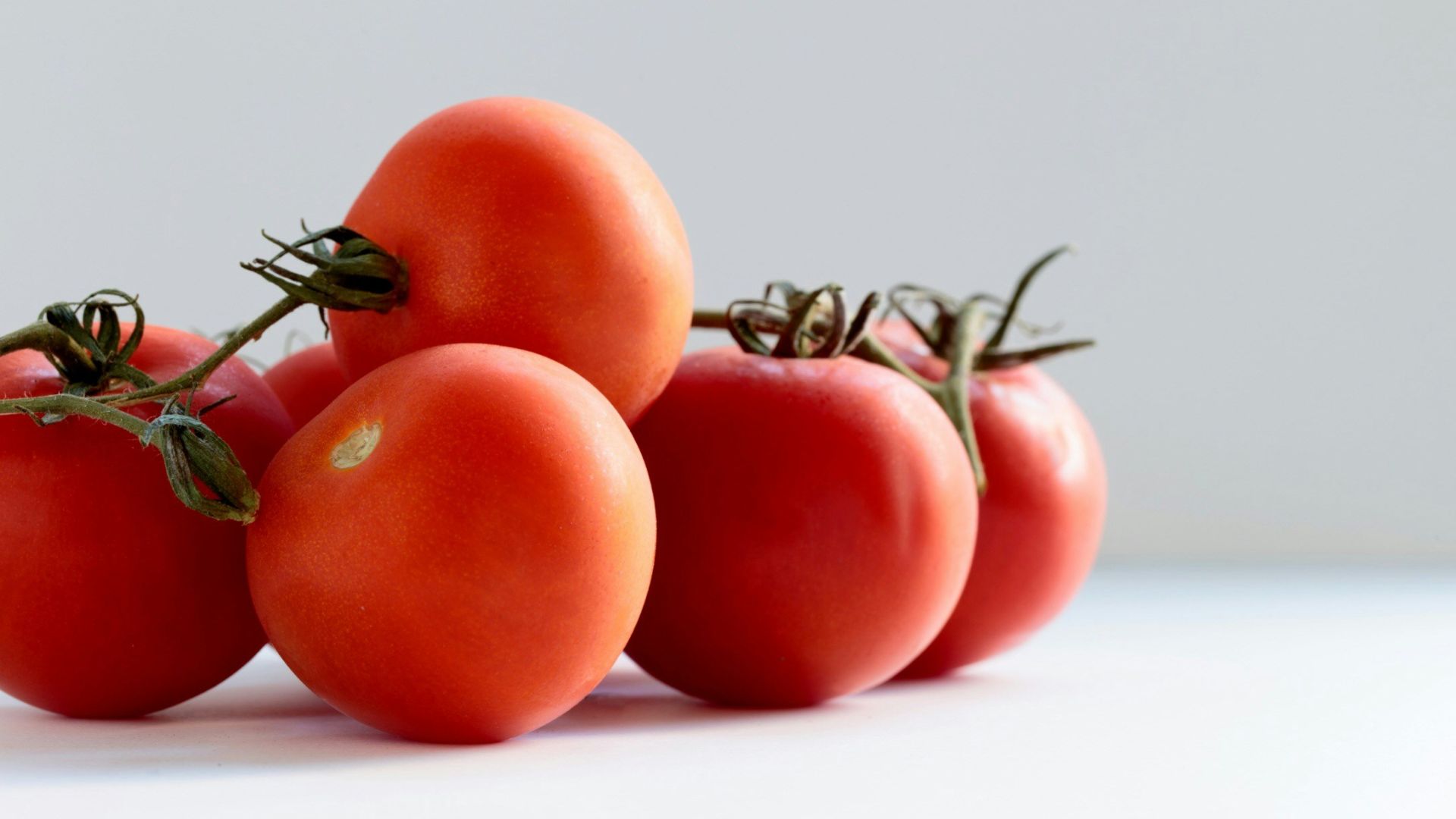 red tomato on white surface