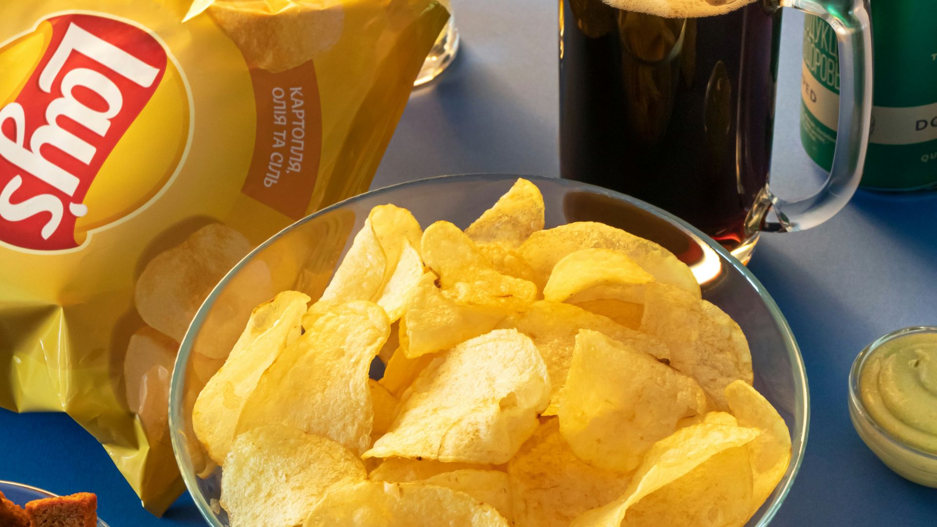 clear drinking glass beside brown bread on blue ceramic plate