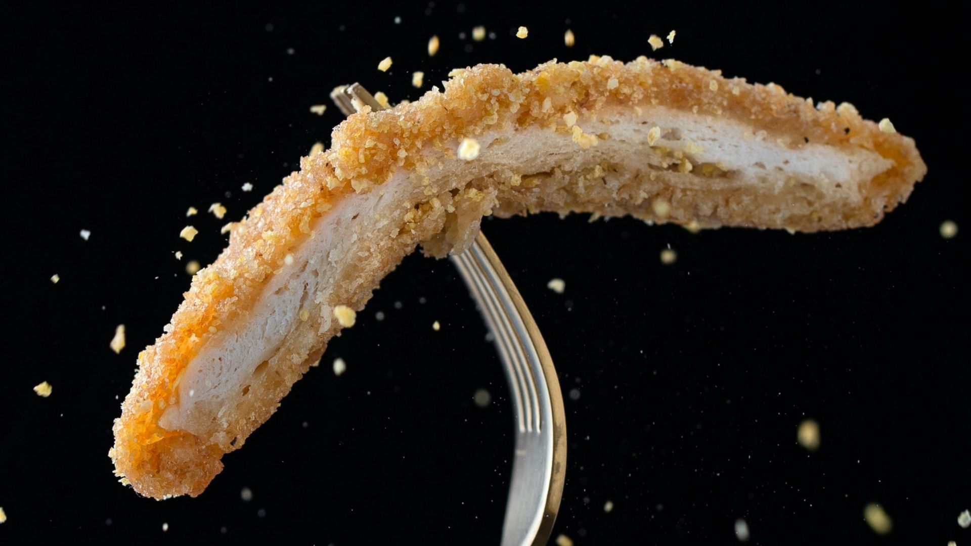 stainless steel fork with sliced breaded meat