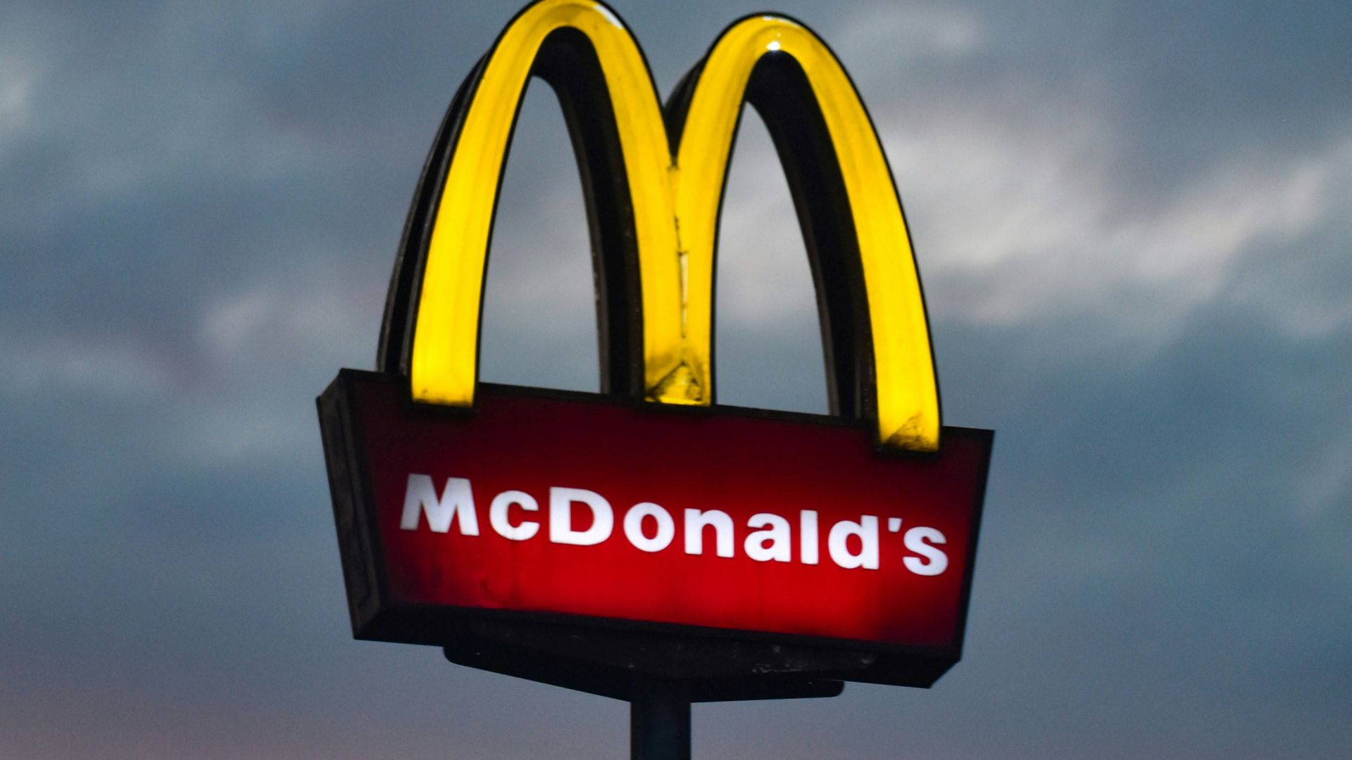 a mcdonald's sign with a cloudy sky in the background