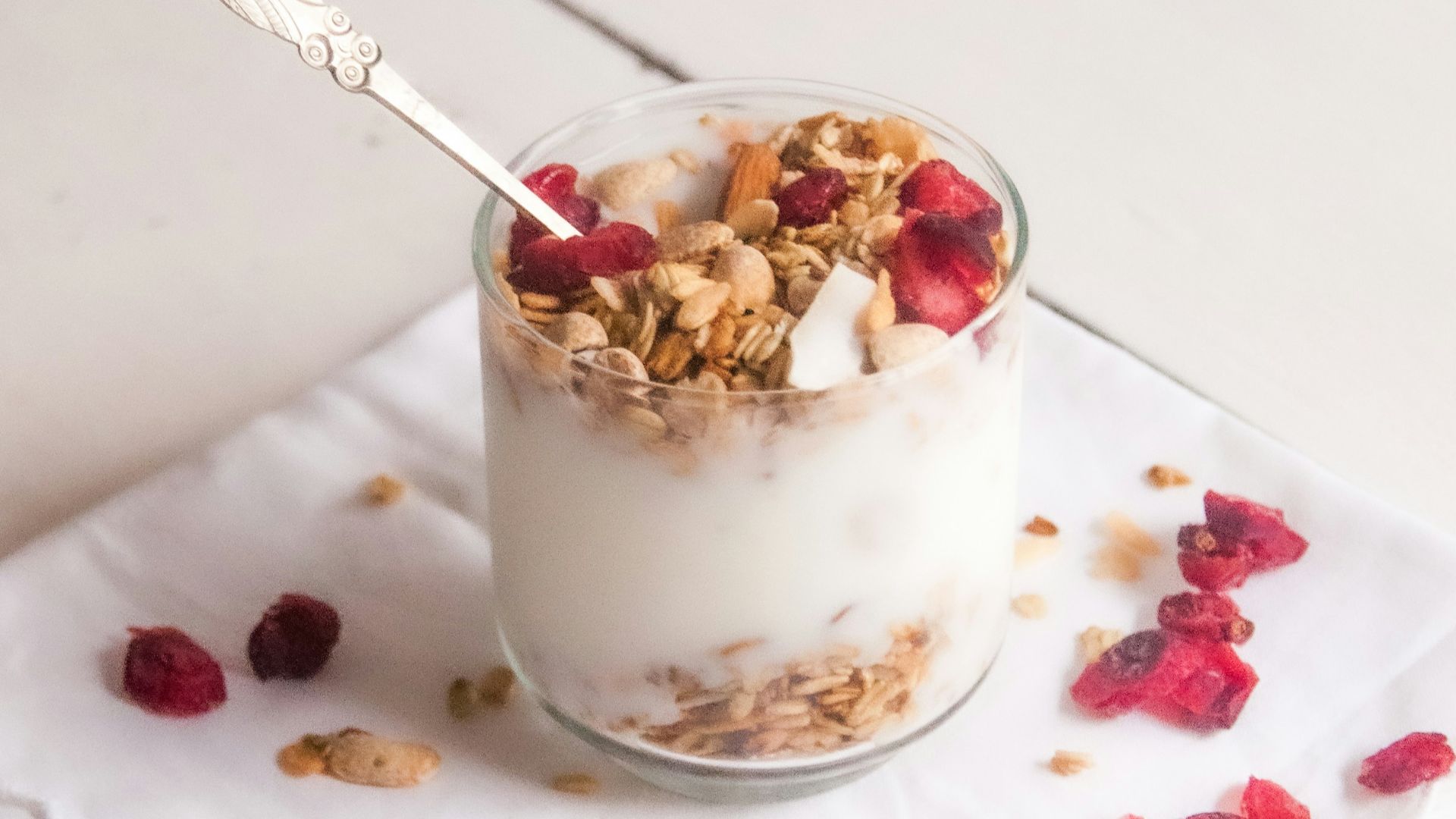 white and brown ceramic cup with stainless steel spoon on white ceramic round plate