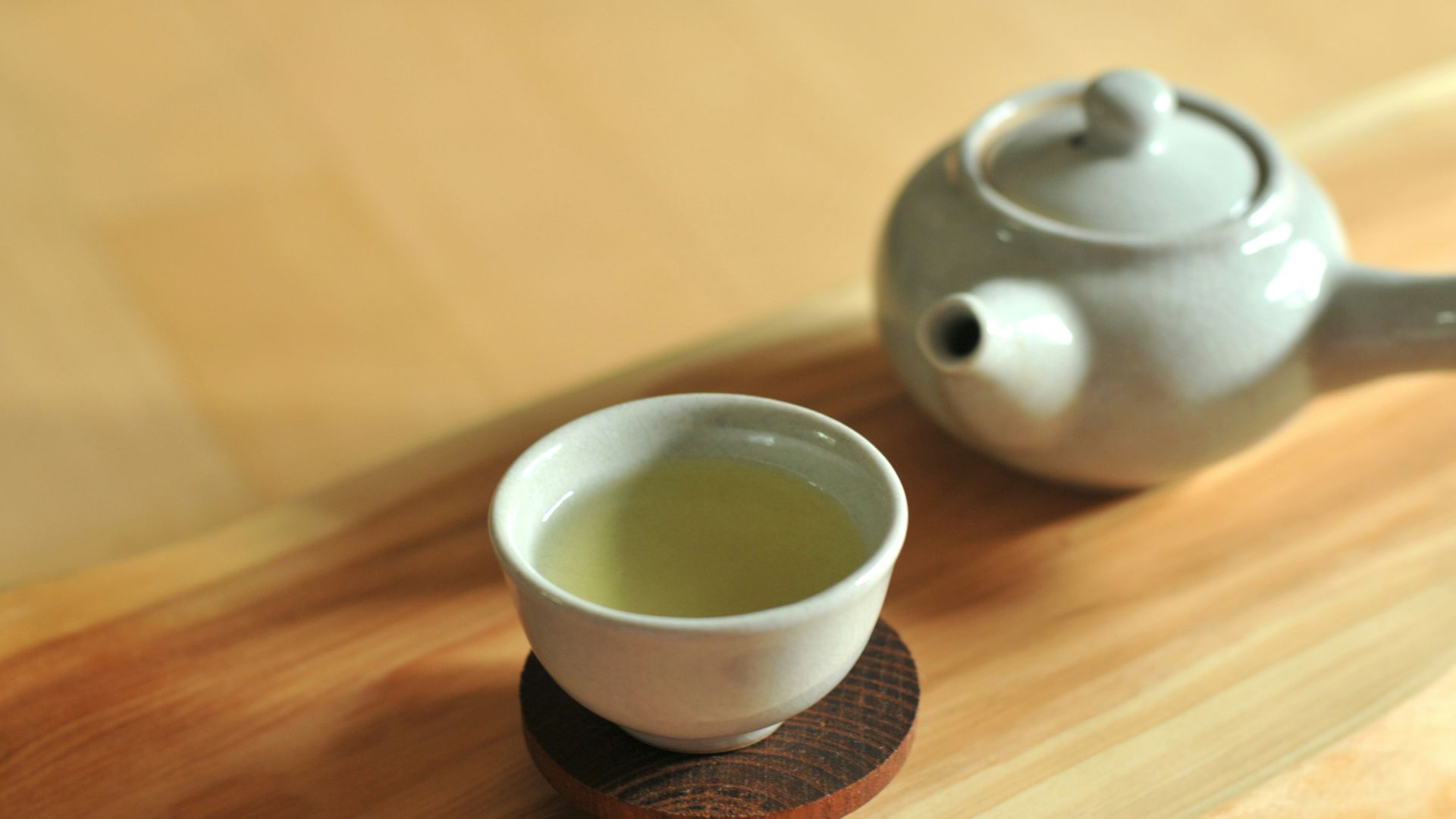 white ceramic teacup on brown wooden table