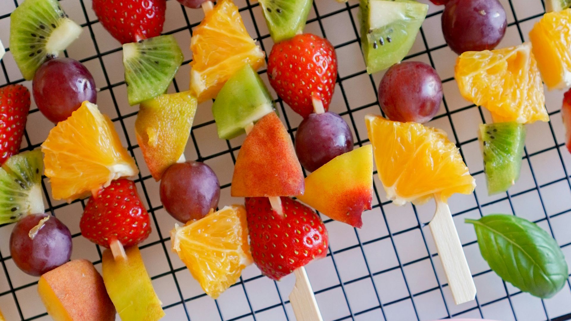 sliced strawberries and bananas on pink plastic plate