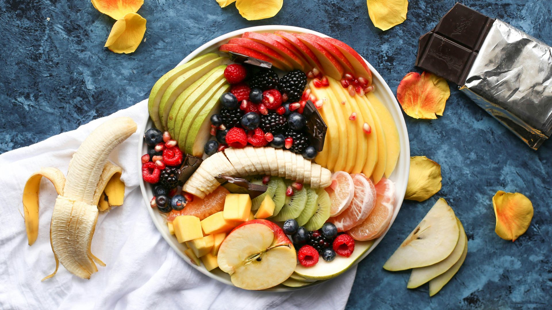 bowl of sliced fruits on white textile
