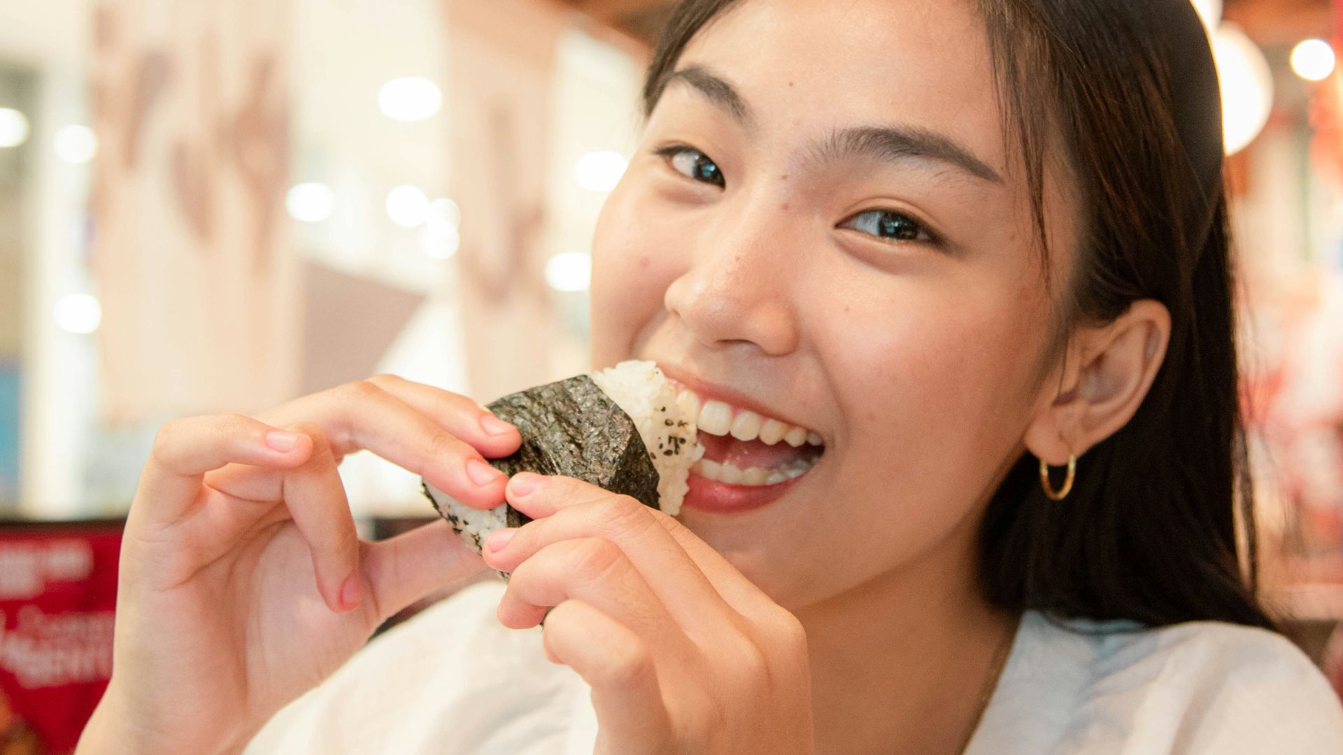 a woman is eating a piece of food