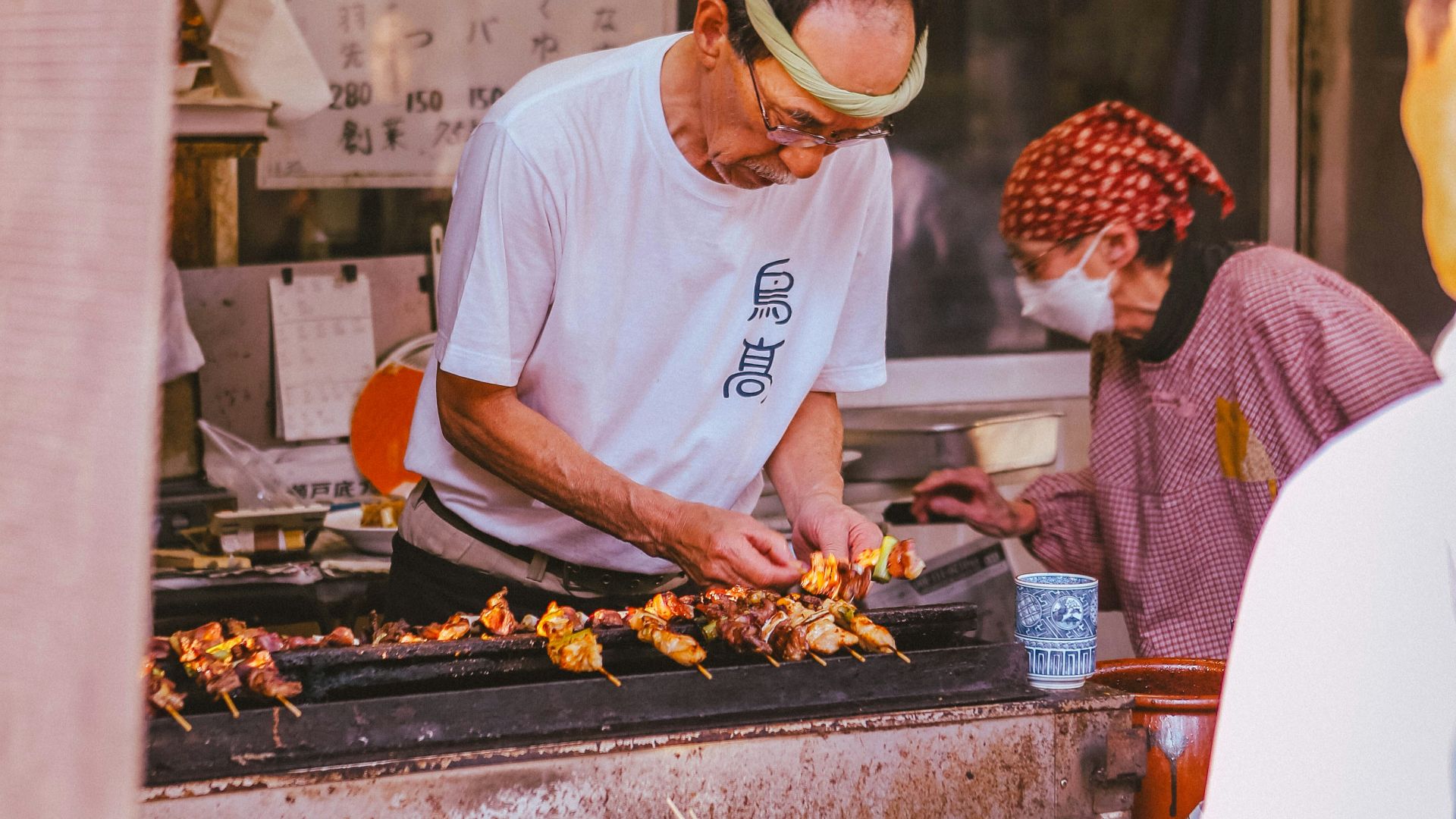 A group of people standing around a kitchen preparing food