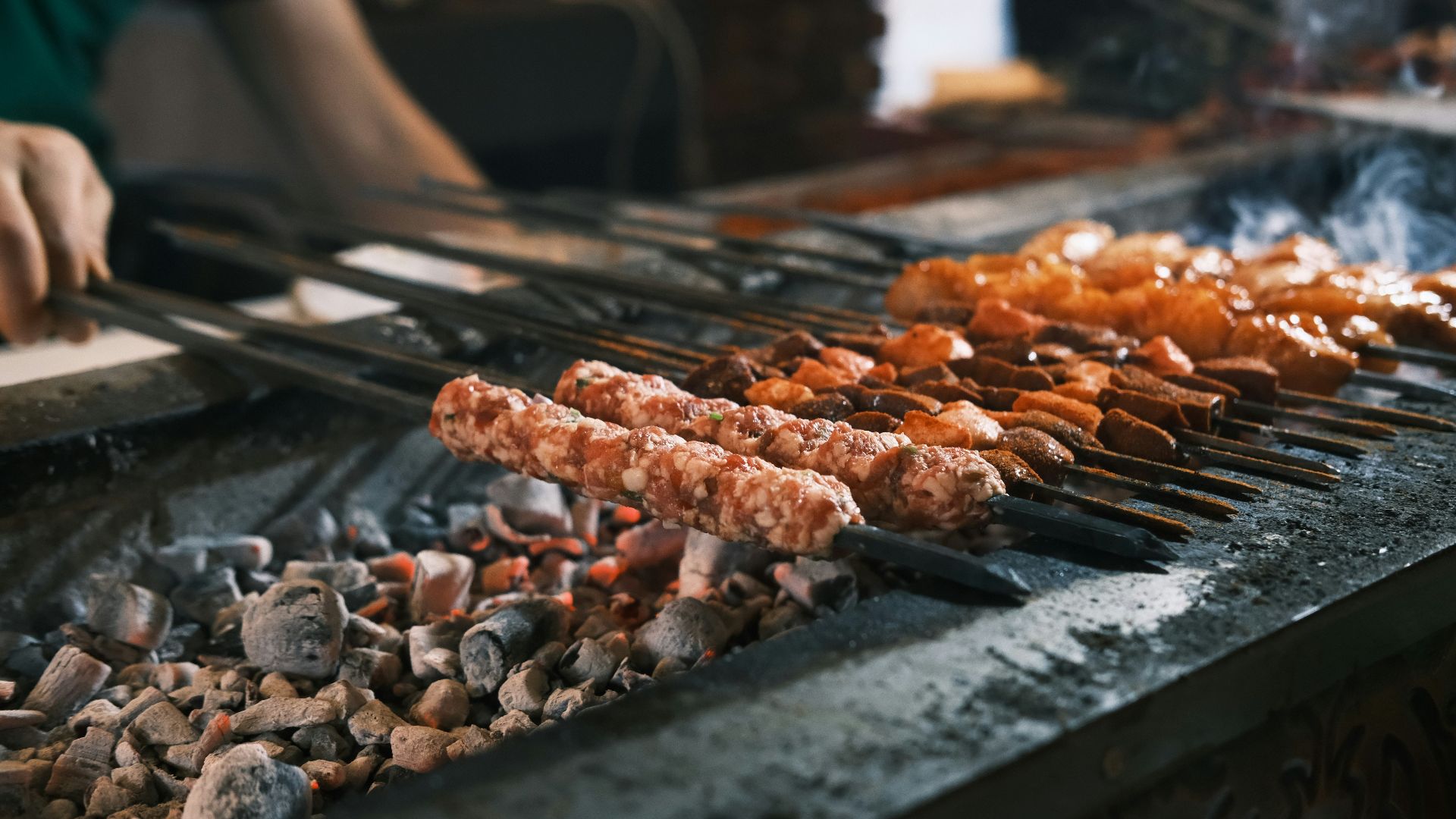 A person cooking food on a grill with tongs