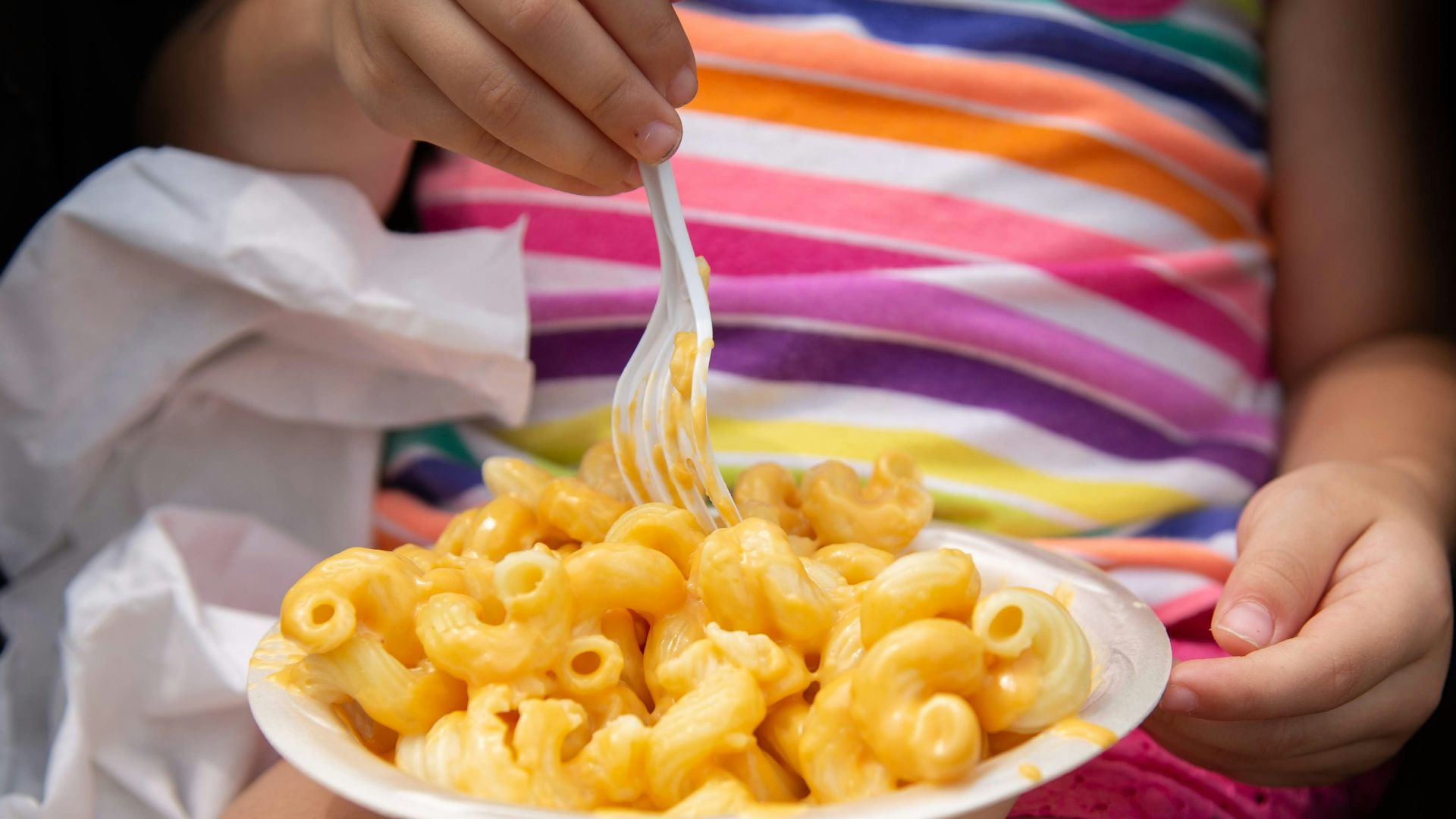 person holding white ceramic bowl with yellow food