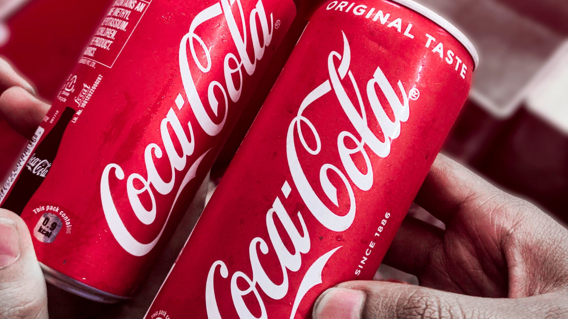 two red-and-white Coca-Cola cans