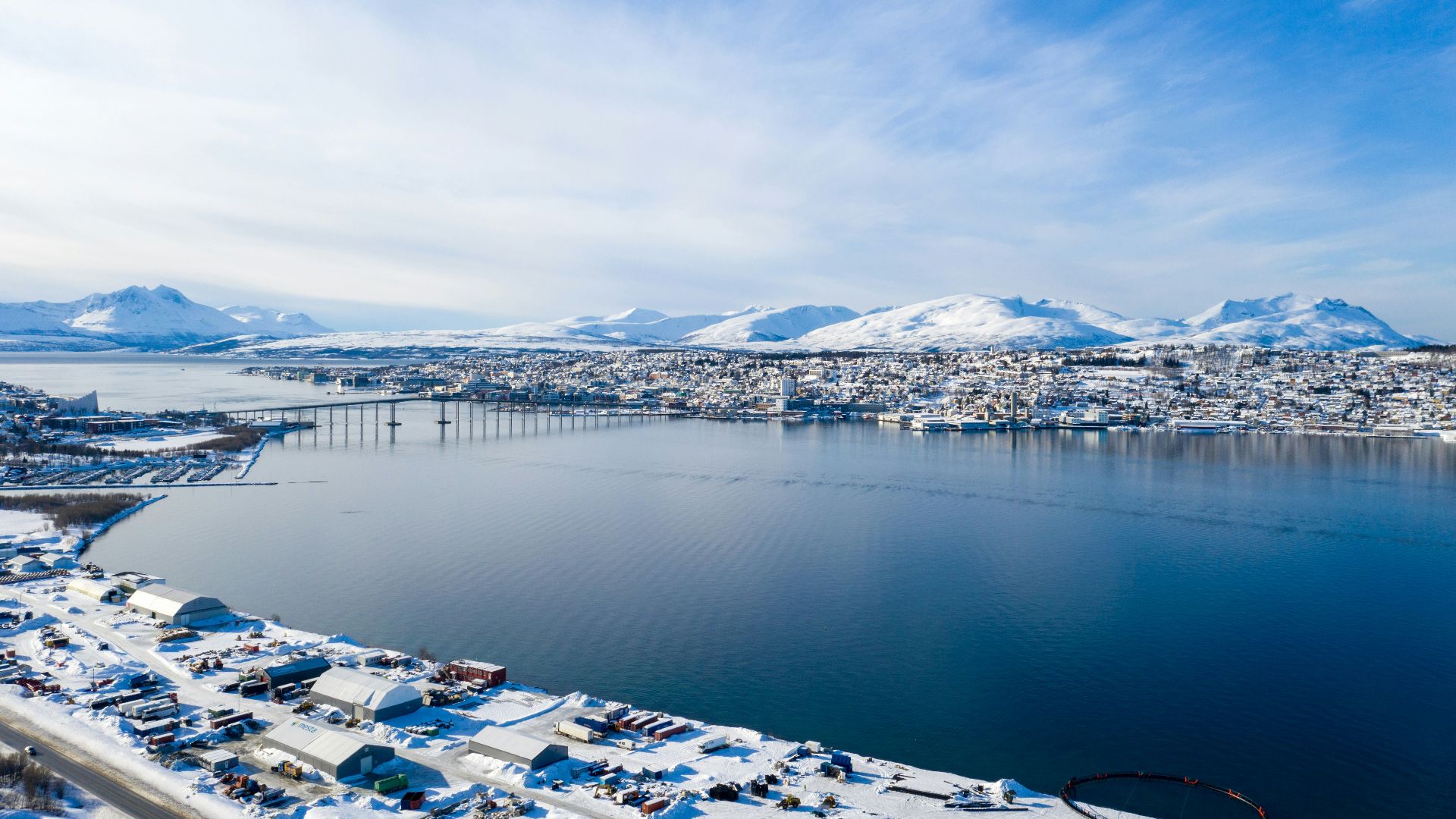 white and blue houses near body of water under white clouds and blue sky during daytime