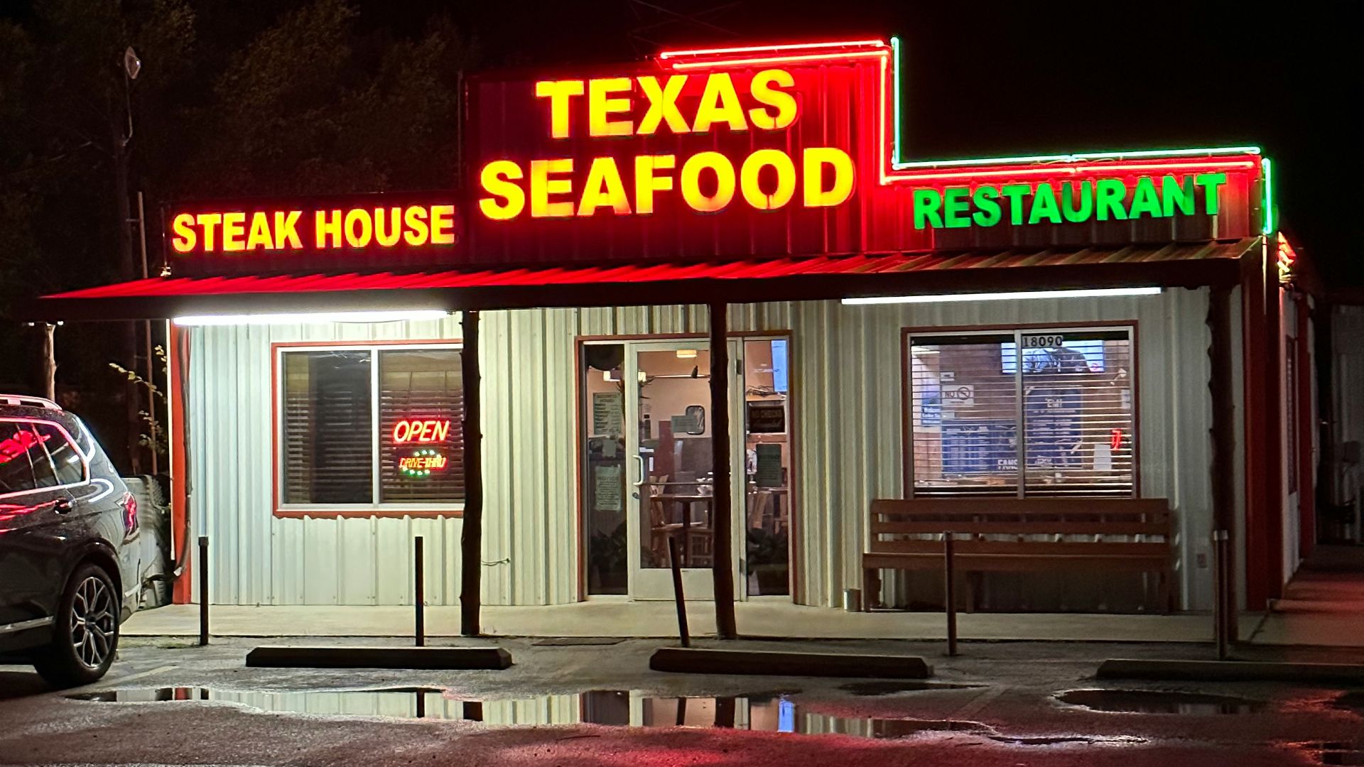 a tex's steak house is lit up at night