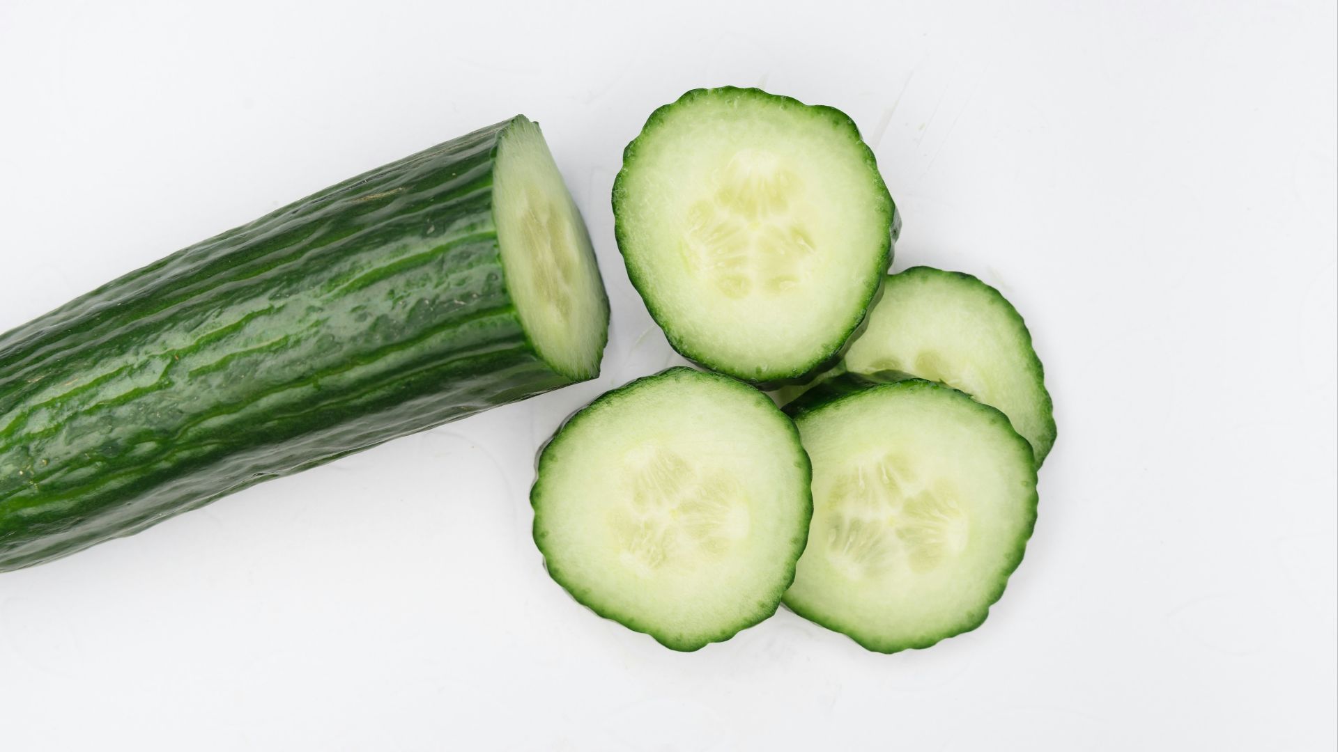 sliced cucumber on white surface